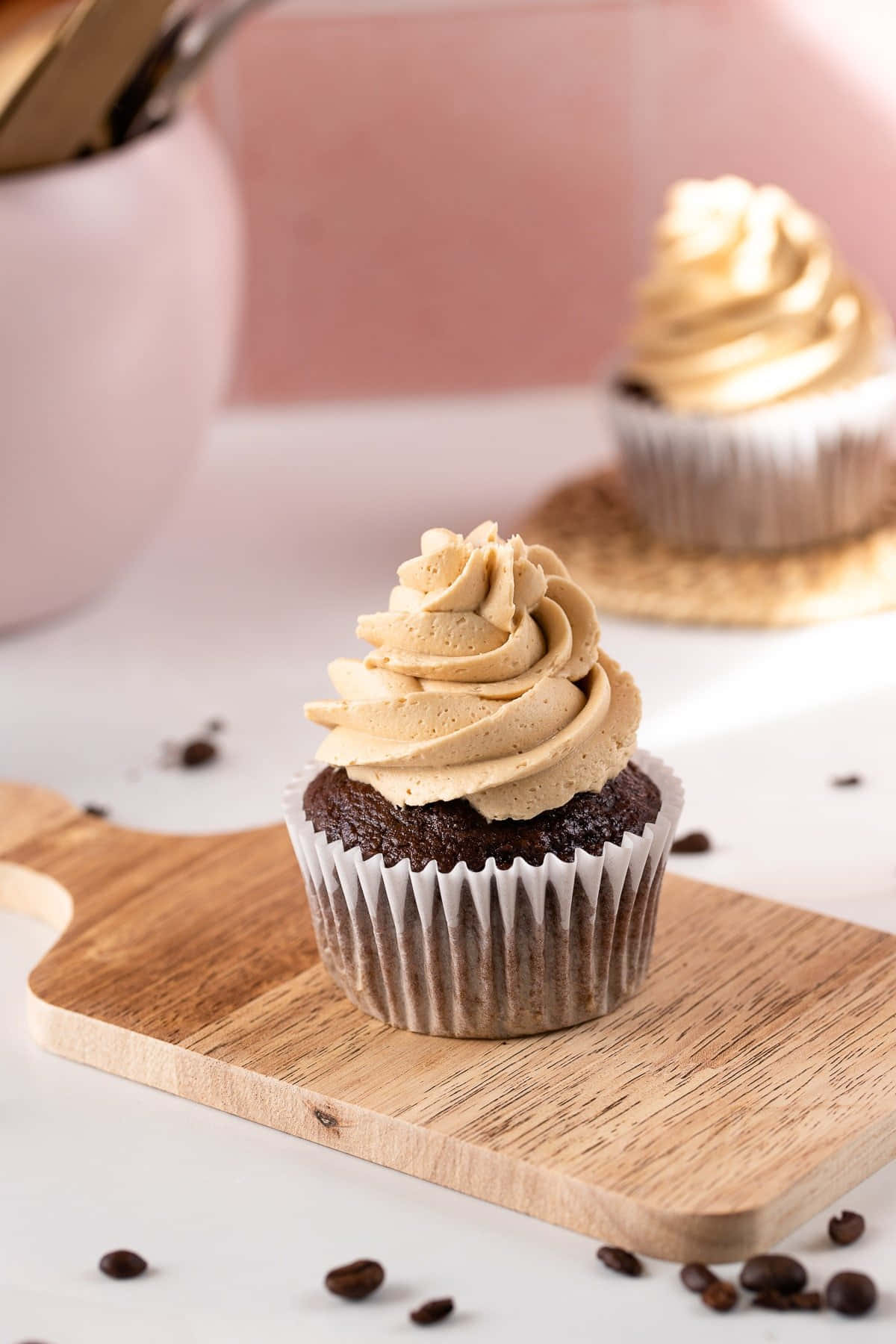 Buttercream 桌布 壁紙 — 一個濃郁的朱古力紙杯蛋糕配上 creamy 焦糖糖霜，放在木板上，周圍環繞著咖啡豆。