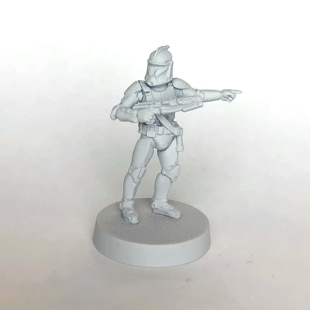 The Clone Army 桌布 壁紙 — 一個灰色未上色的星際大戰複製人兵迷你模型站在圓形底座上，用爆能槍指向前方。