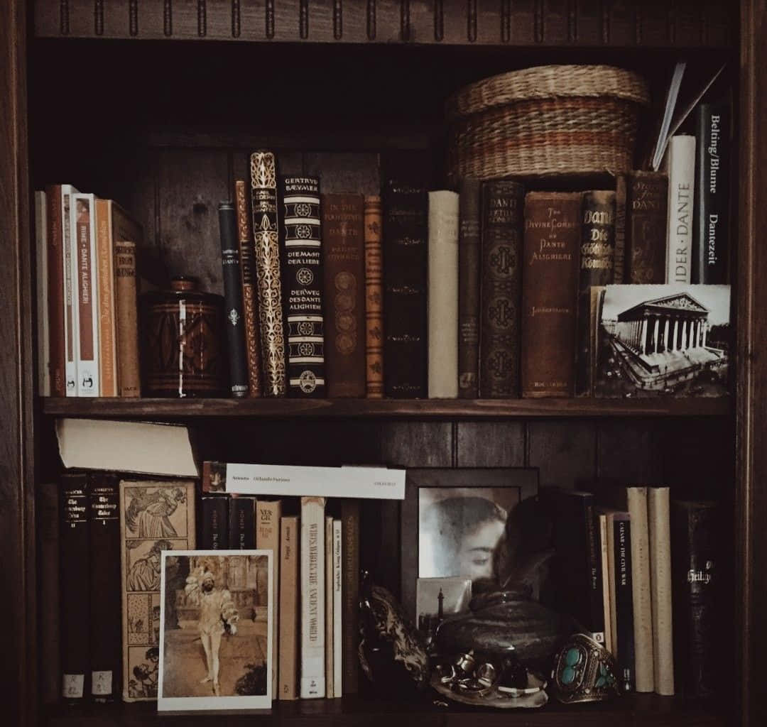 Dark Academia Aesthetic 桌布 壁紙 — 一個燈光昏暗的木製書架，裝滿了復古書籍、照片和裝飾品，營造出舒適的學術氛圍。