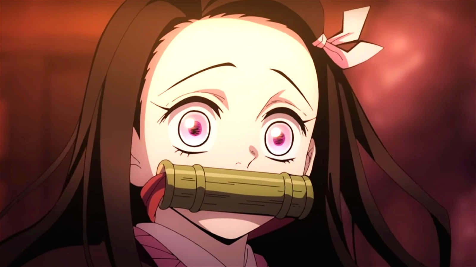 Demon Slayer Characters 桌布 壁紙 — 一個特寫動漫女孩，擁有寬大的粉紅色眼睛和長長的深色頭髮，嘴裡含著竹製口塞，背景是火紅色的。