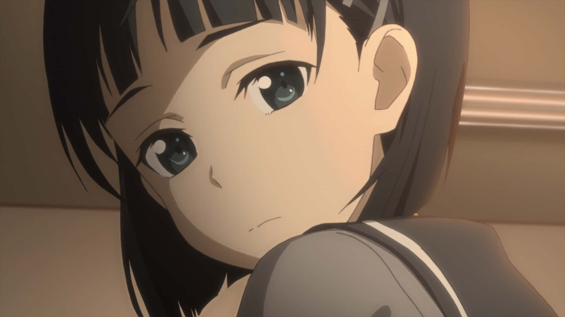 Suguha Kirigaya 桌布 壁紙 — 一個特寫動漫女孩，深色頭髮和藍色眼睛，在溫暖的室內燈光下微微皺眉回頭看。