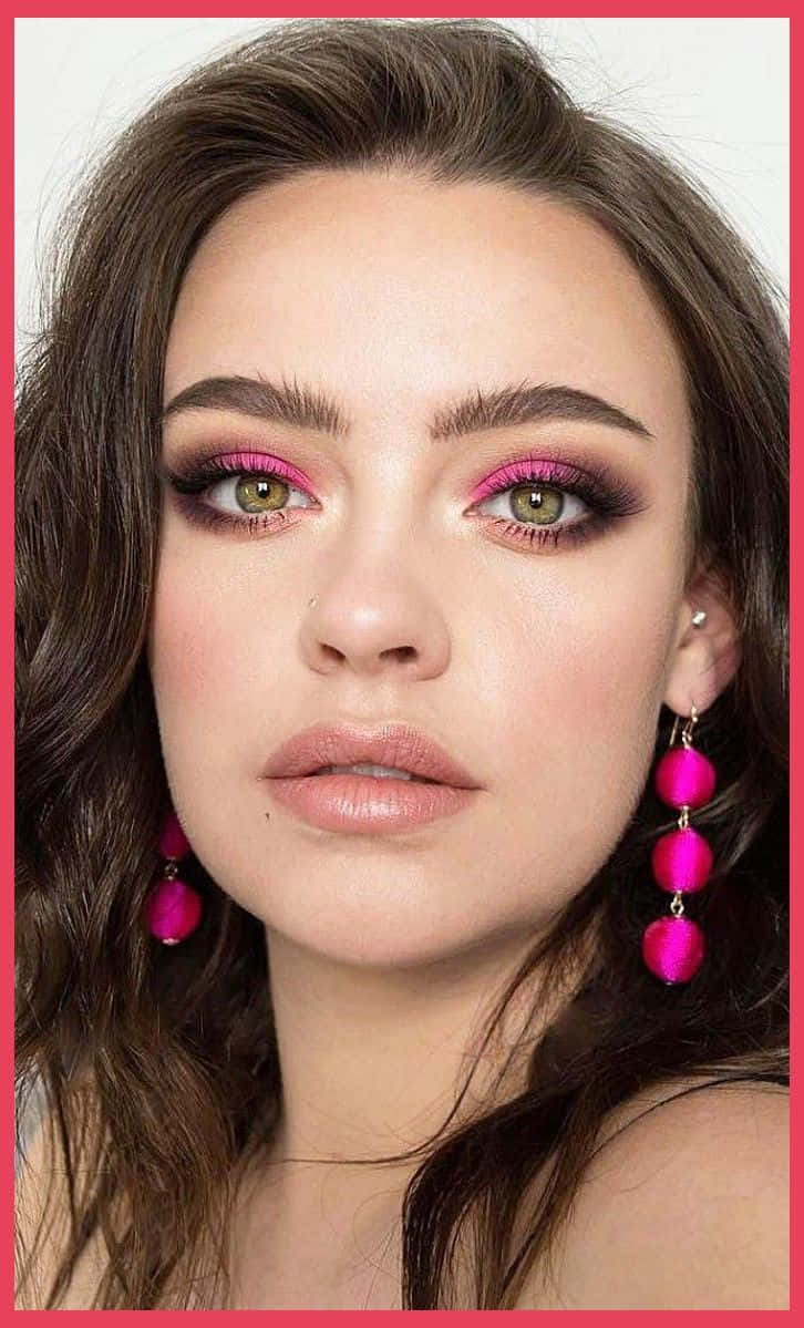 Spring Makeup 桌布 壁紙 — 一個特寫肖像，女性塗上大膽的粉紅色眼影，佩戴相配的吊墜耳環，背景為純色。