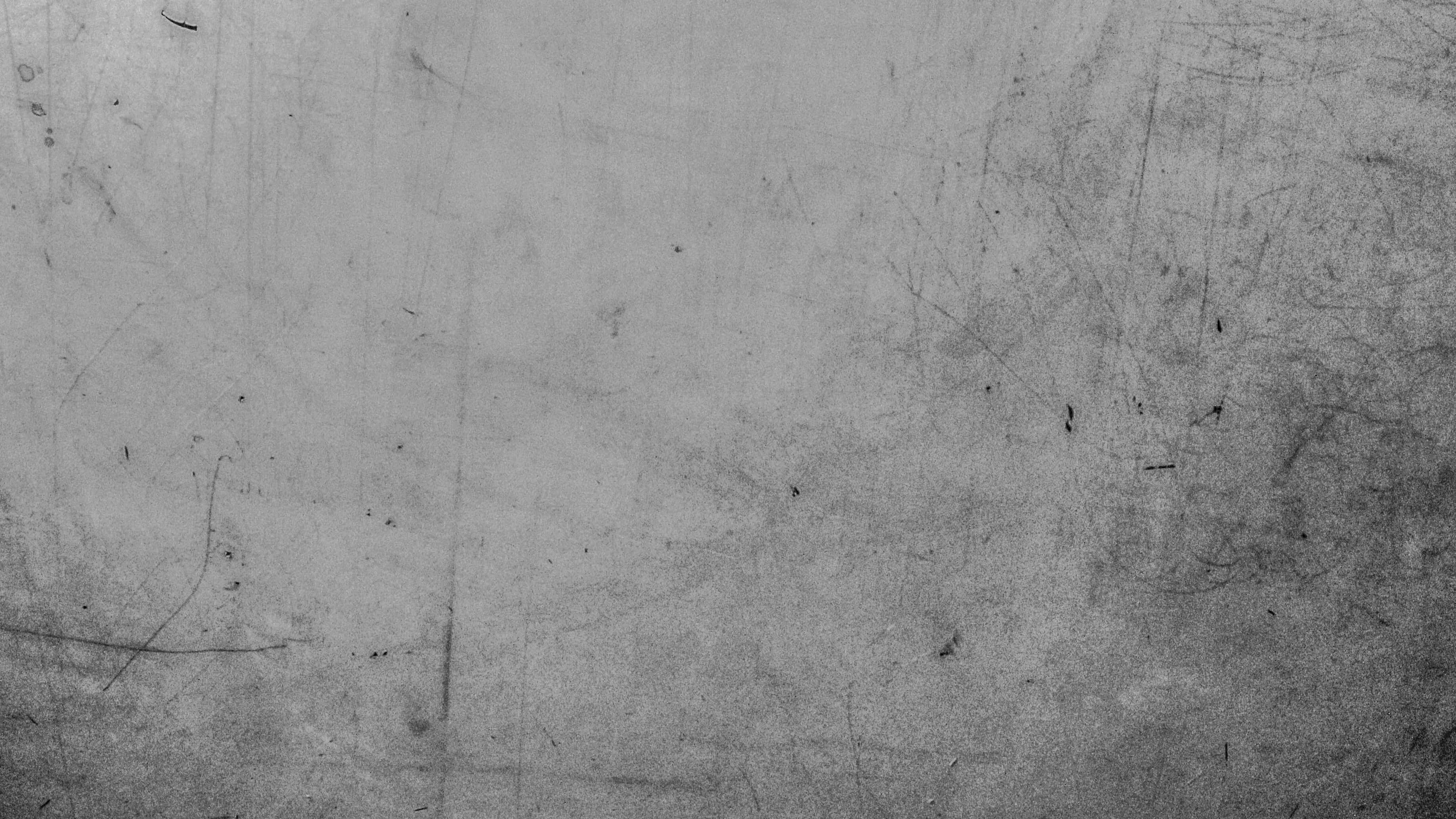 灰色美學 桌布 壁紙 — 一個特寫鏡頭，展示一塊佈滿刮痕和磨損的風化金屬表面，帶有粗糙的單色紋理。