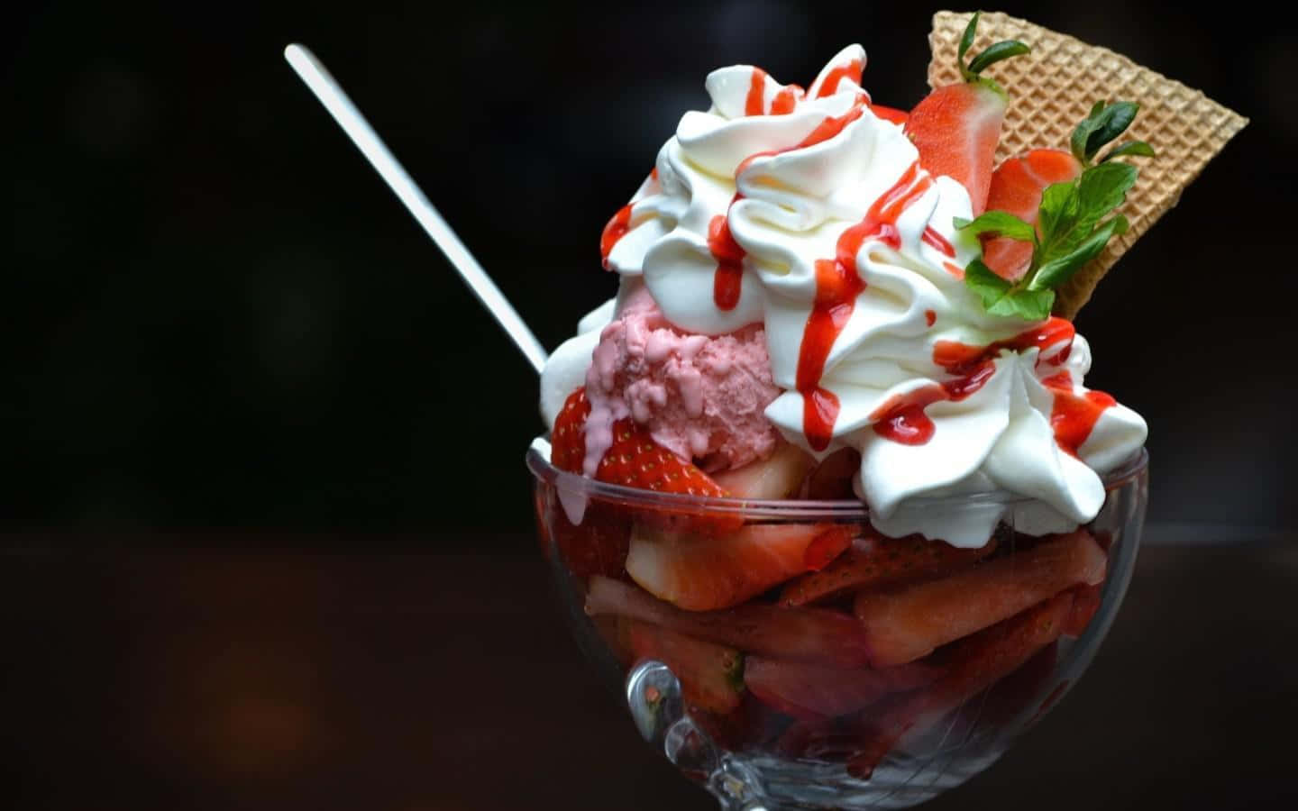 Ice Cream 桌布 壁紙 — 一個玻璃碗盛滿草莓冰淇淋，上面放有鮮奶油、草莓醬、新鮮草莓、薄荷和一個窩夫筒。