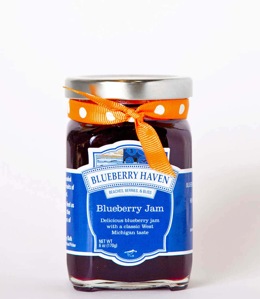 Blueberry Jam 桌布 壁紙 — 一個玻璃罐裝藍莓果醬，帶有藍色標籤和一條橙色絲帶綁在銀色蓋子上。