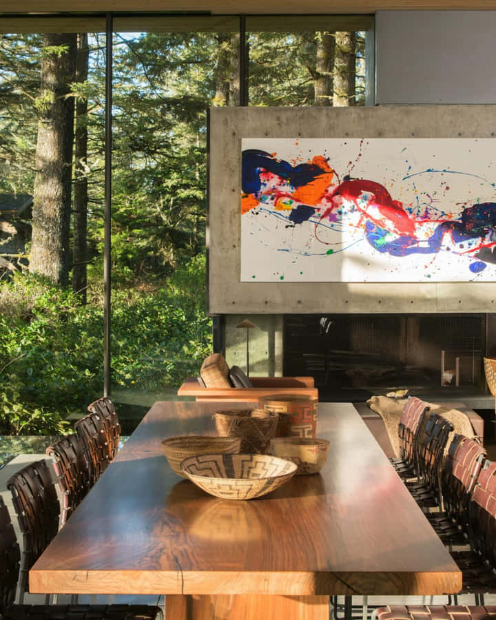 Interior Design 桌布 壁紙 — 一個現代化的飯廳，設有長木桌和編織椅，透過落地窗俯瞰茂密的森林。