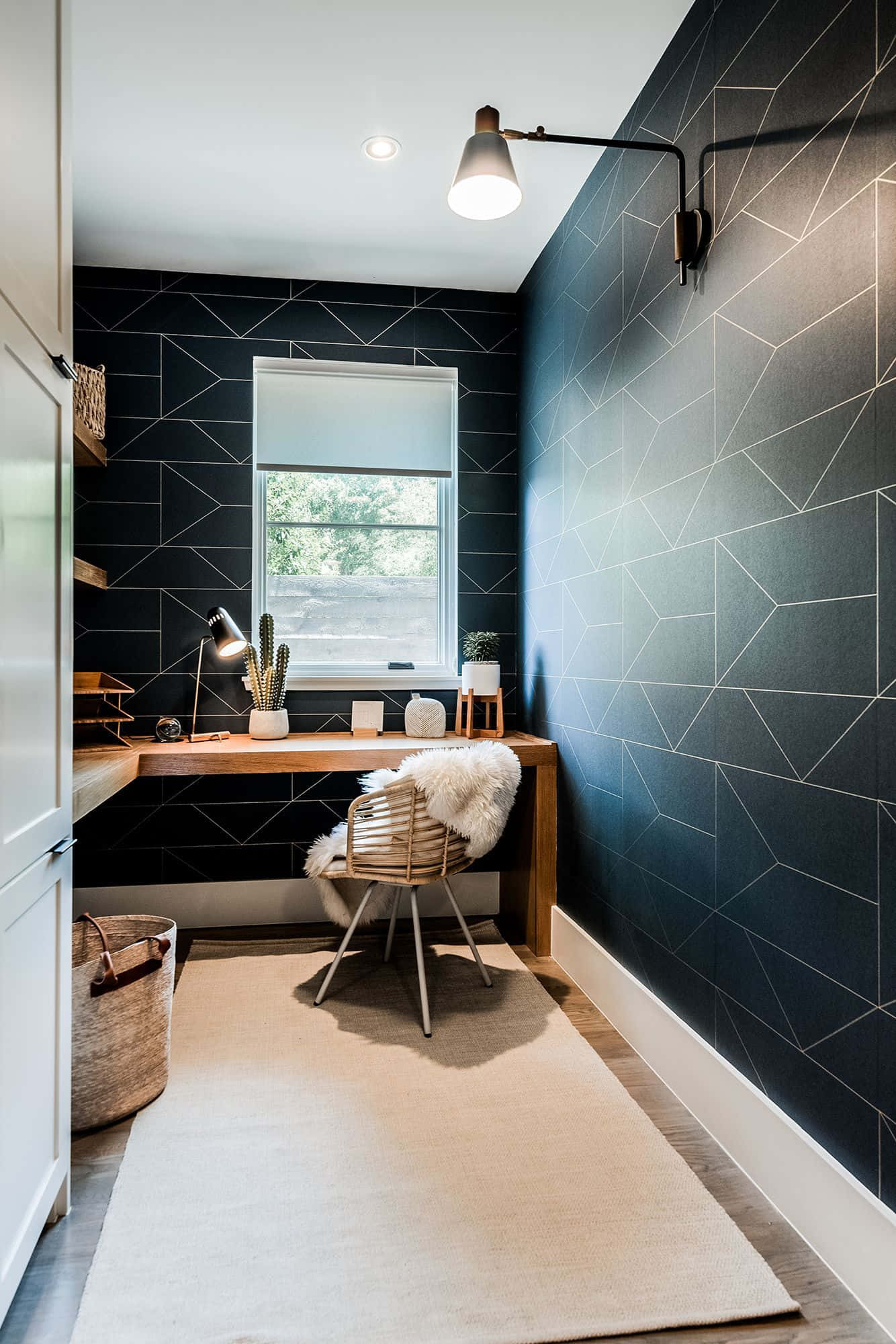 HD Office Background Home Working Space 壁紙 — 一個現代家居辦公室，設有深色幾何圖案瓷磚牆、木桌和編織椅，位於明亮的窗戶下。
