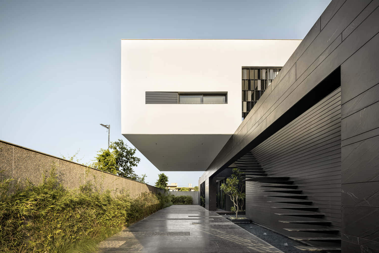 Minimalist Architecture 桌布 壁紙 — 一個現代建築奇蹟，在清澈藍天下，有一個漂浮的白色立方體和深灰色條紋牆壁。