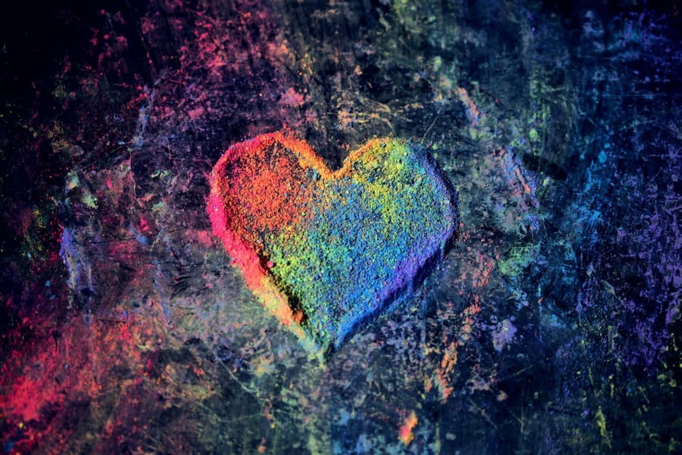 Heart Art 桌布 壁紙 — 一個由彩色粉末製成的充滿活力的彩虹心在深色紋理背景上發光。