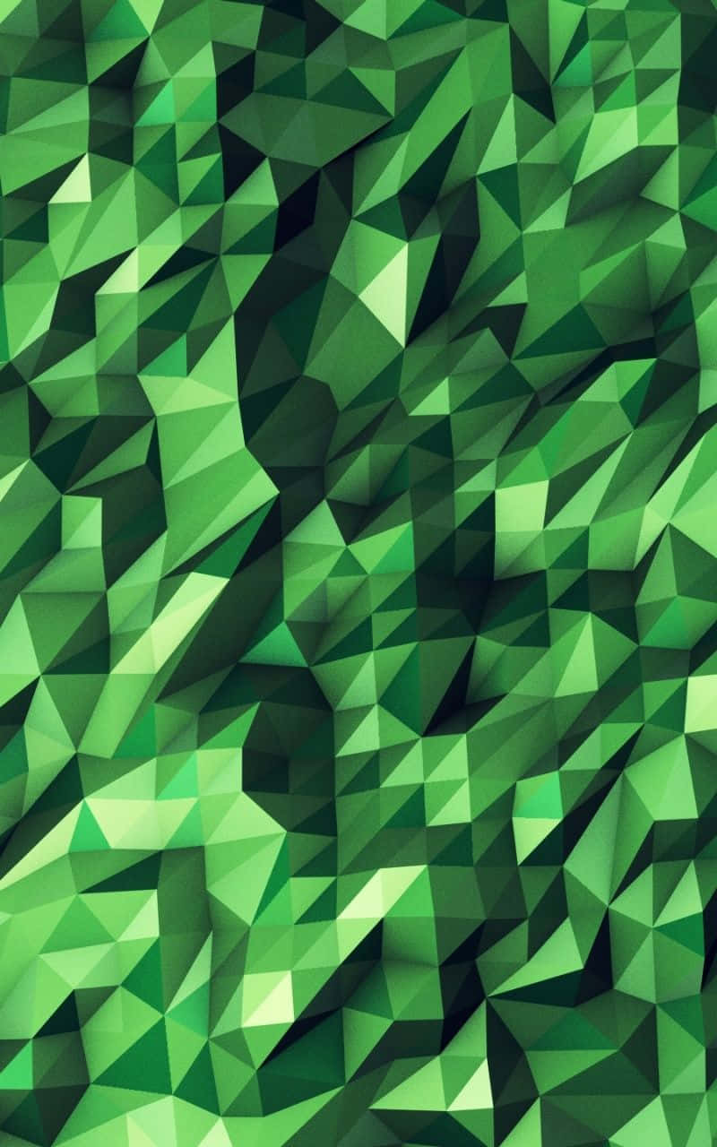 Green Geometric 桌布 壁紙 — 一個由綠色多邊形面構成的動態抽象圖案，營造出帶有紋理的三維表面。