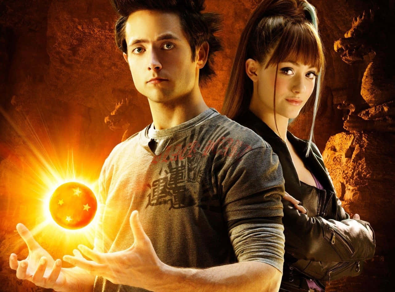 Dragon Ball Movies 桌布 壁紙 — 一個男人和一個女人站在一個熾熱的洞穴中，一顆發光的龍珠懸浮在他的手中。