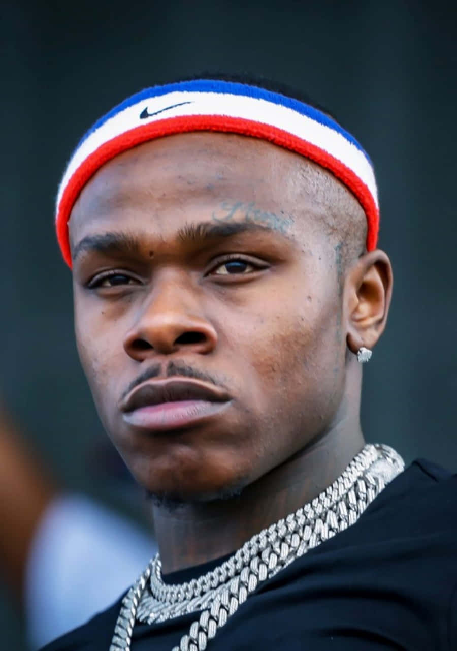 Dababy 桌布 壁紙 — 一個男人嘅特寫肖像，佢戴住紅白藍色嘅Nike頭帶同粗銀鏈，背景係模糊嘅黑暗。