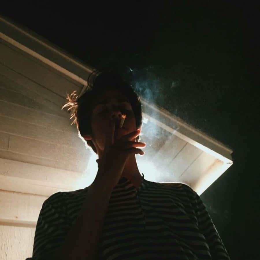 一個男人在一間屋前吸煙 壁紙