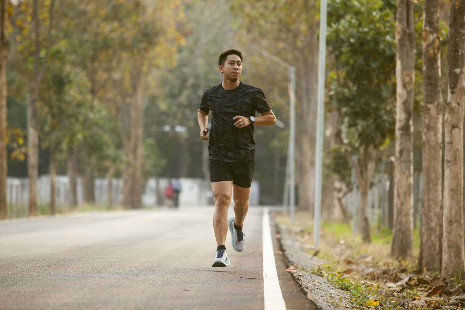 一個男人在森林中的路上奔跑 壁紙