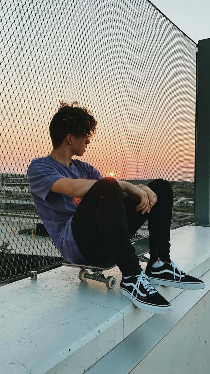 一個男人坐在滑板上 壁紙