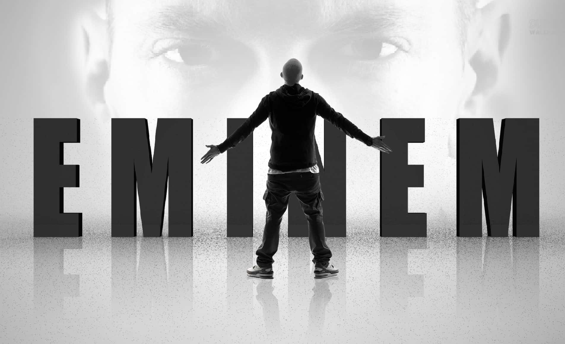 Eminem 桌布 壁紙 — 一個男人張開雙臂站在巨大的3D字母前，這些字母拼出EMINEM，背景是他自己的臉。