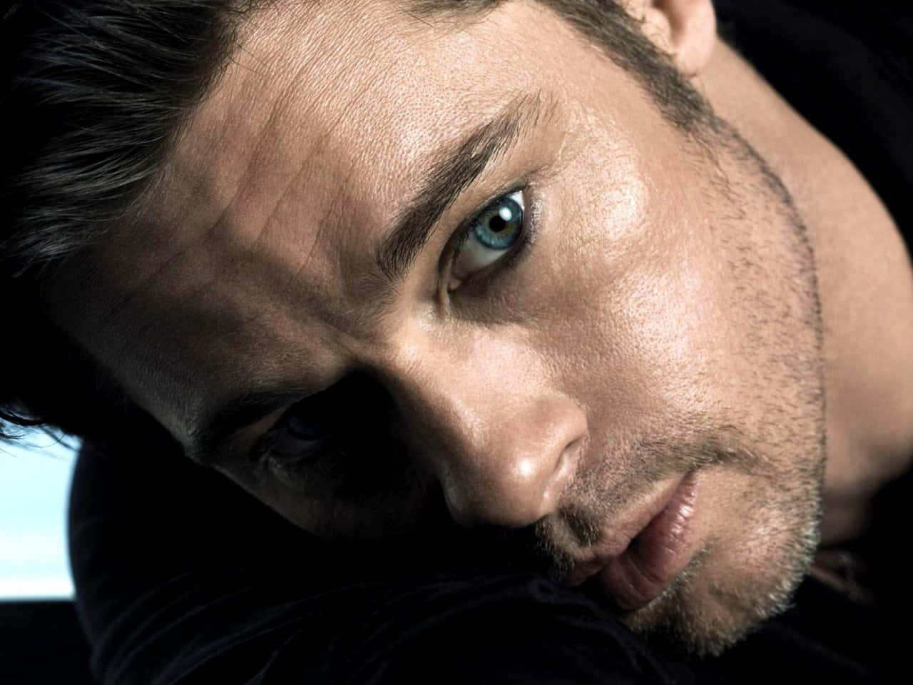 Brad Pitt 桌布 壁紙 — 一個男人強烈的藍眼睛和飽經風霜的臉在陰暗燈光下的戲劇性特寫。