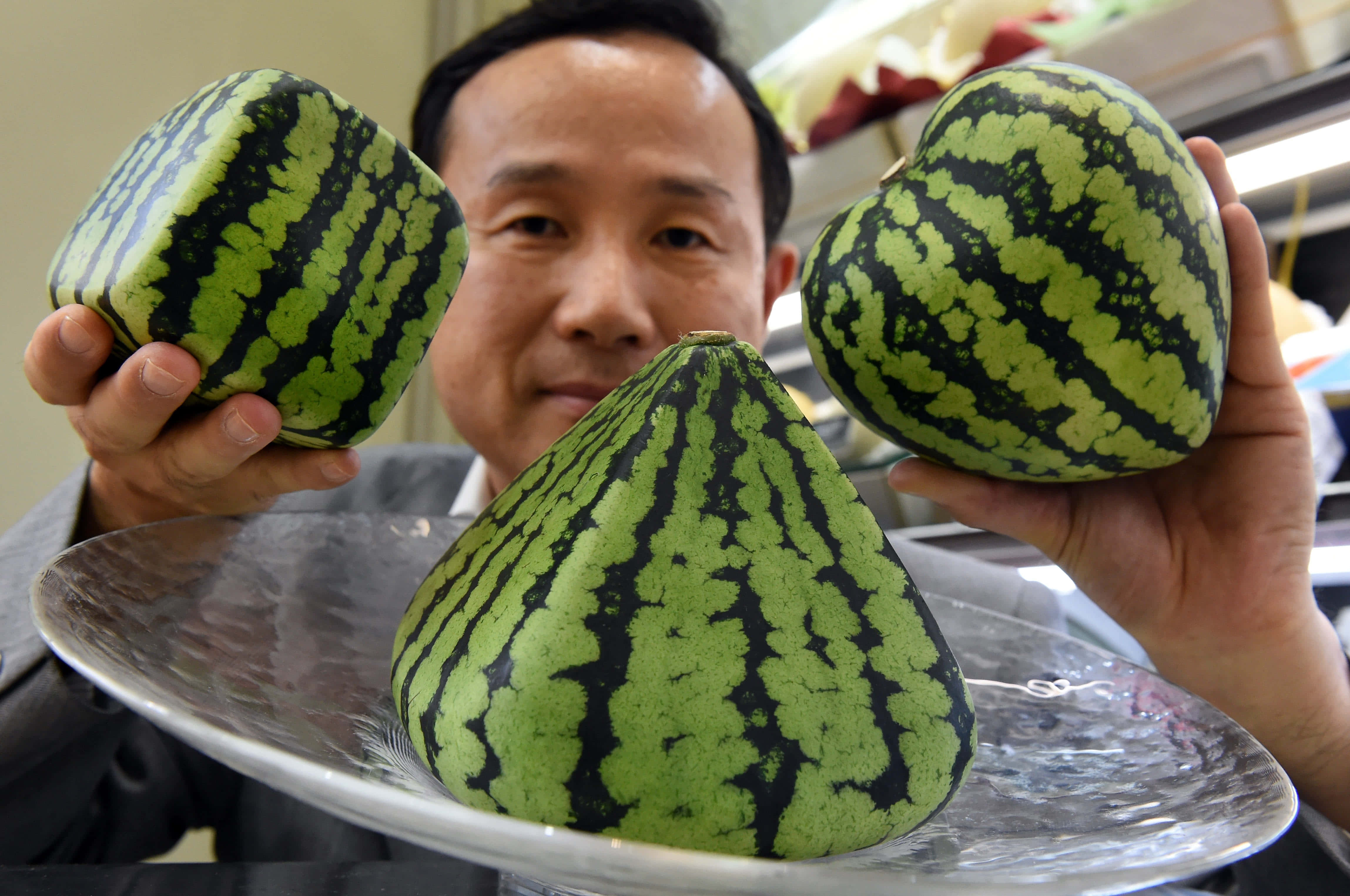 一個男人拎住三塊西瓜切片 壁紙
