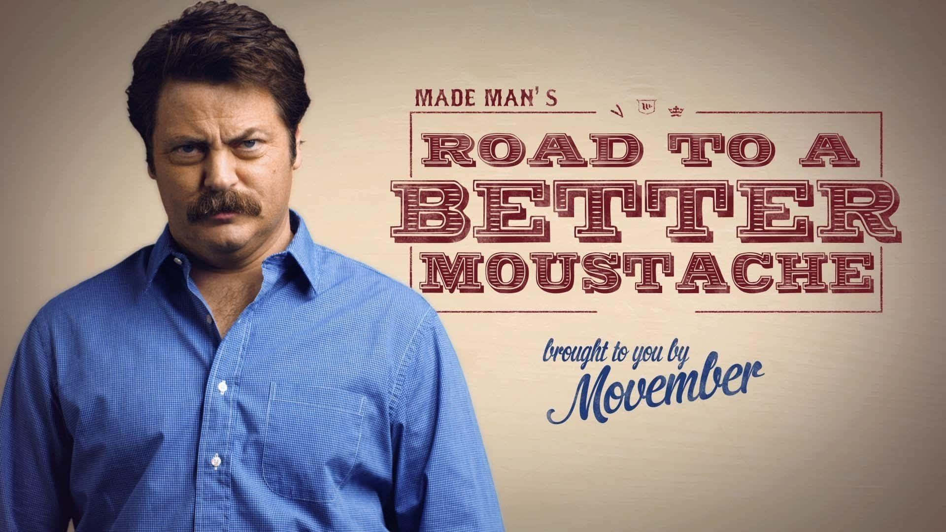 nick offerman 桌布 壁紙 — 一個留著濃密鬍鬚、身穿藍色襯衫的男人，在粗體紅色文字「Road to a Better Moustache」和「brought to you by Movember」旁邊嚴肅地凝視著。