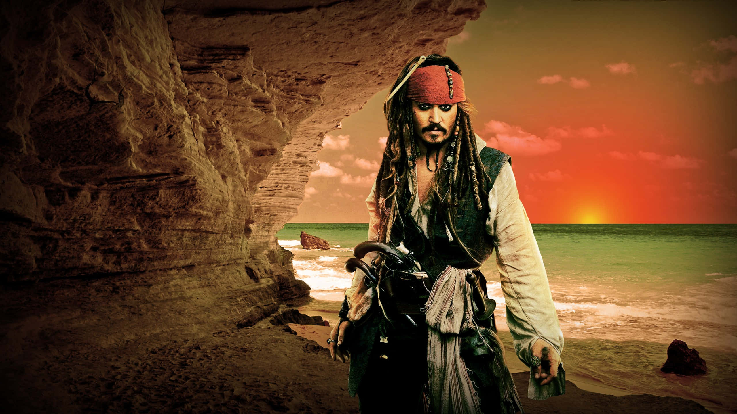 Pirates Of The Caribbean 桌布 壁紙 — 一個留著辮子頭、戴紅色頭巾的海盜站在岩石洞穴入口，身後熾熱的夕陽在海面上閃耀。