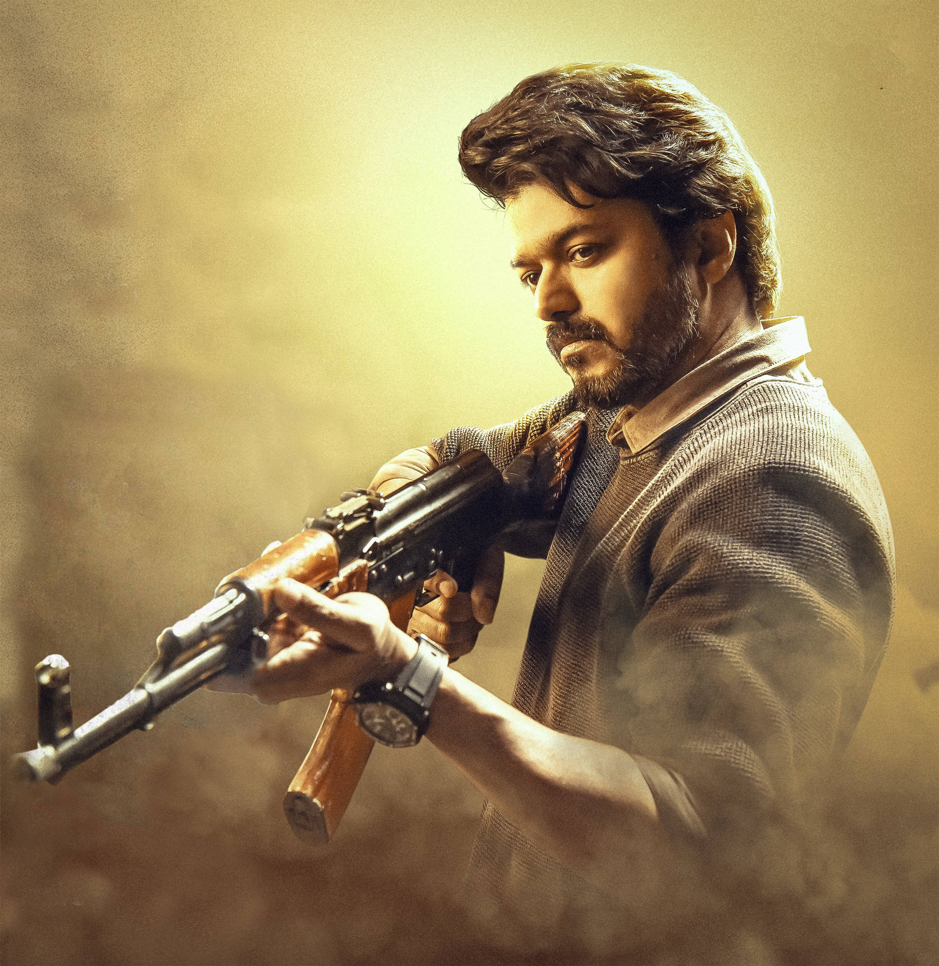 vijay HD 桌布 壁紙 — 一個留鬍子的男人在煙霧彌漫、金色燈光的場景中，專注地握著一支AK-47步槍。