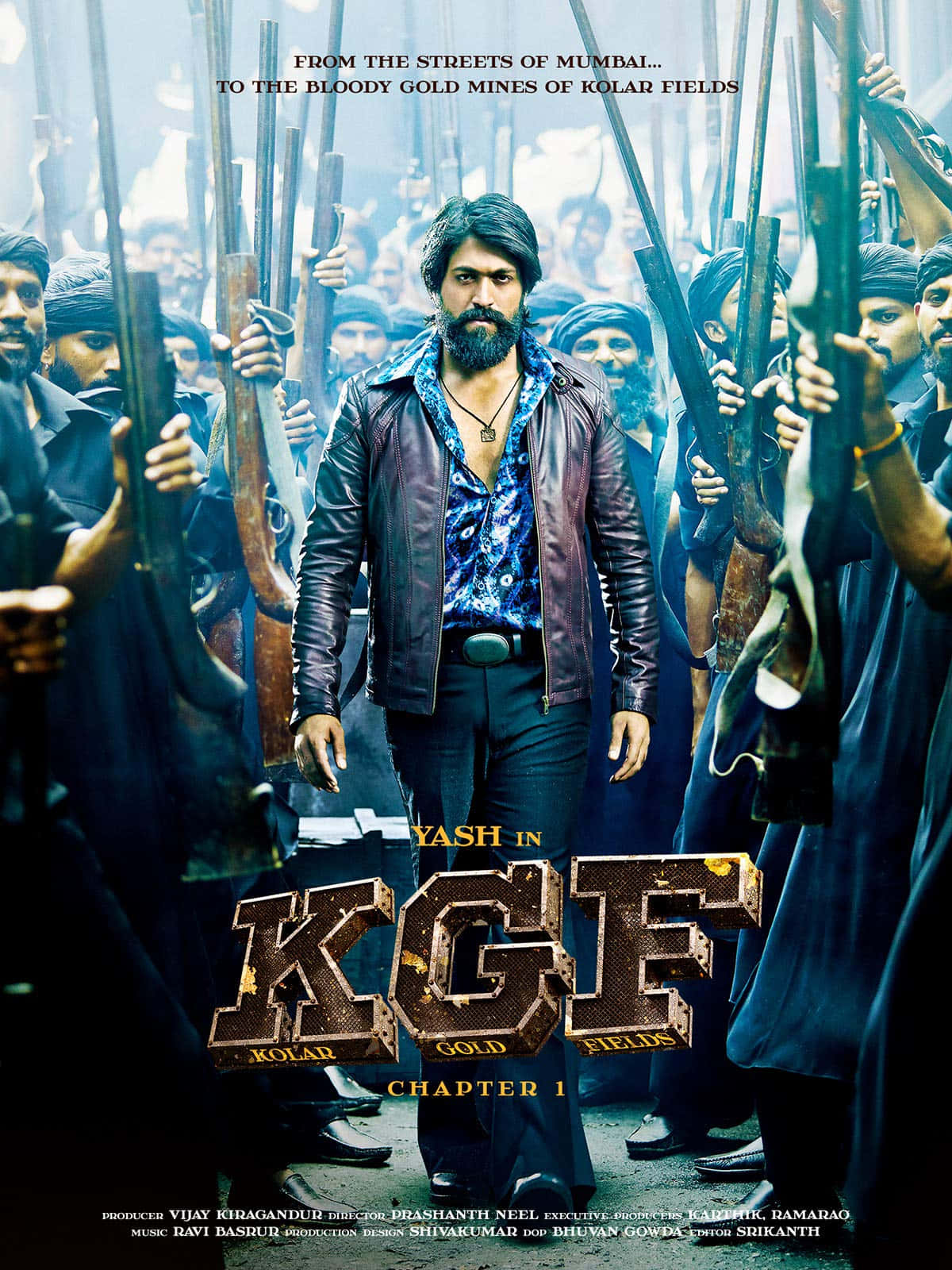 Kgf 2 桌布 壁紙 — 一個留鬍鬚、穿皮褸嘅男人，喺一個粗獷嘅電影感動作場景中，挑釁咁企喺一群持槍男人中間。