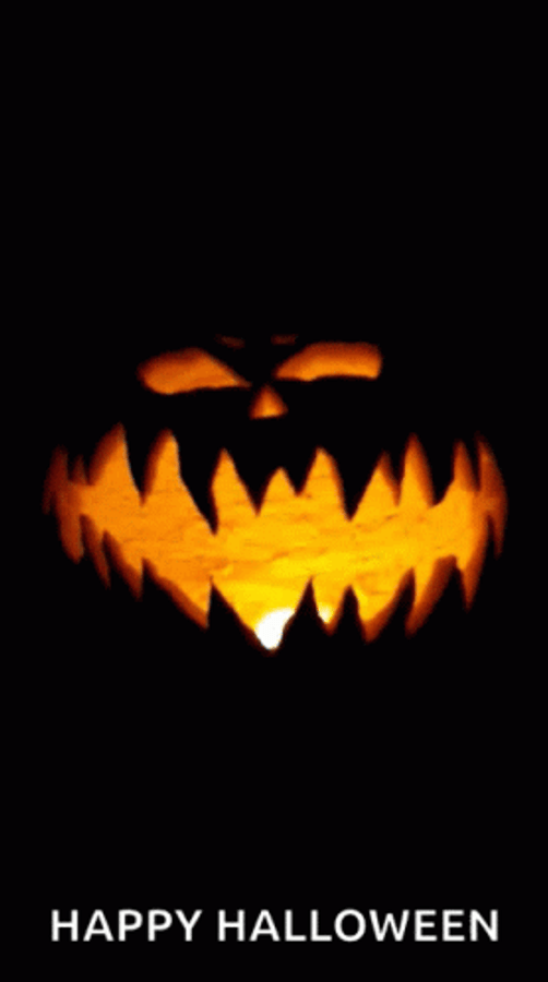 Spooky 桌布 壁紙 — 一個發光的傑克南瓜燈，帶有鋸齒狀的牙齒和狹窄的眼睛，在黑色背景上照亮黑暗。