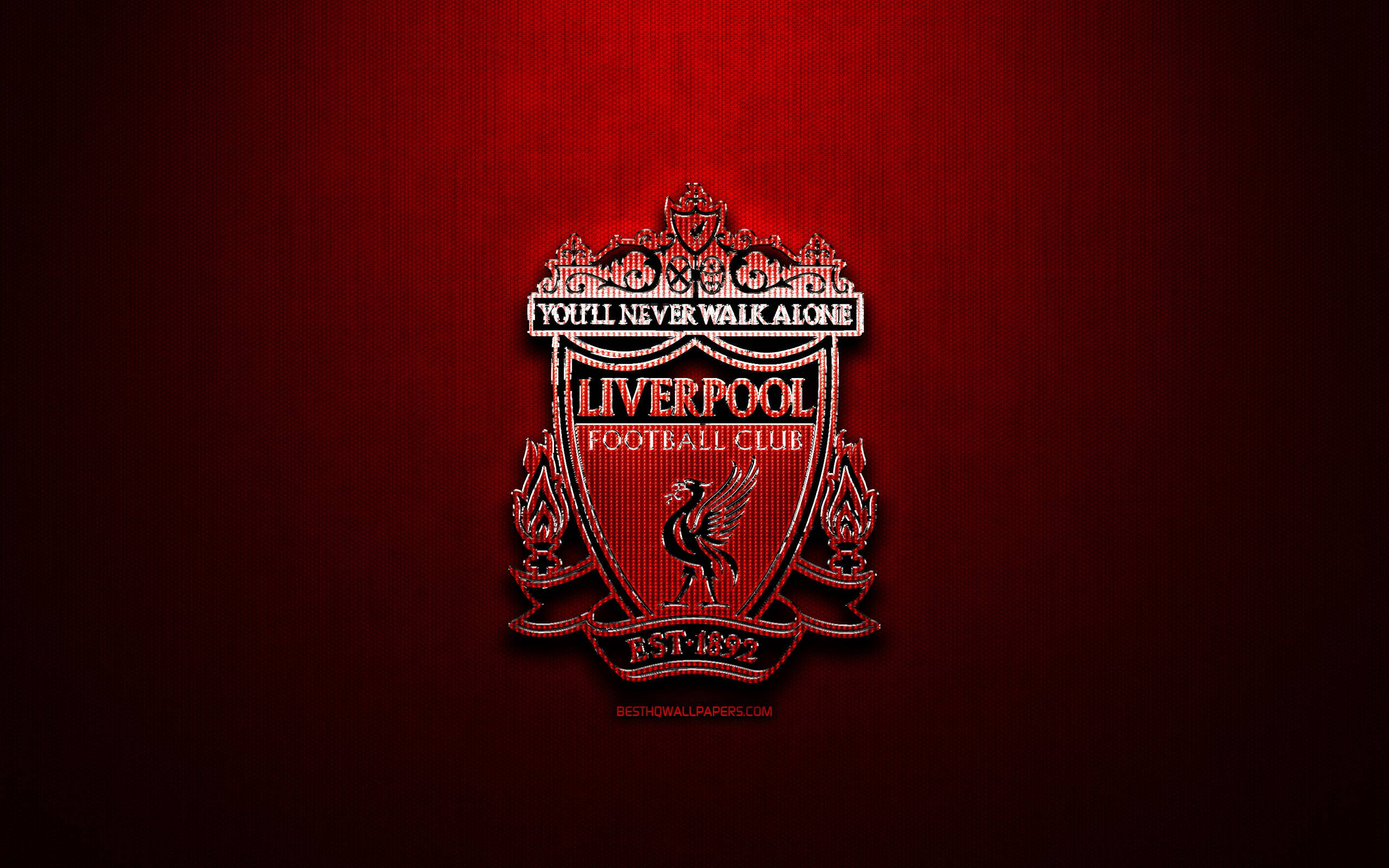 Liverpool Fc 桌布 壁紙 — 一個發光的利物浦足球會徽章，居中於帶有紋理的深紅色漸變背景上，帶有微妙的光線。