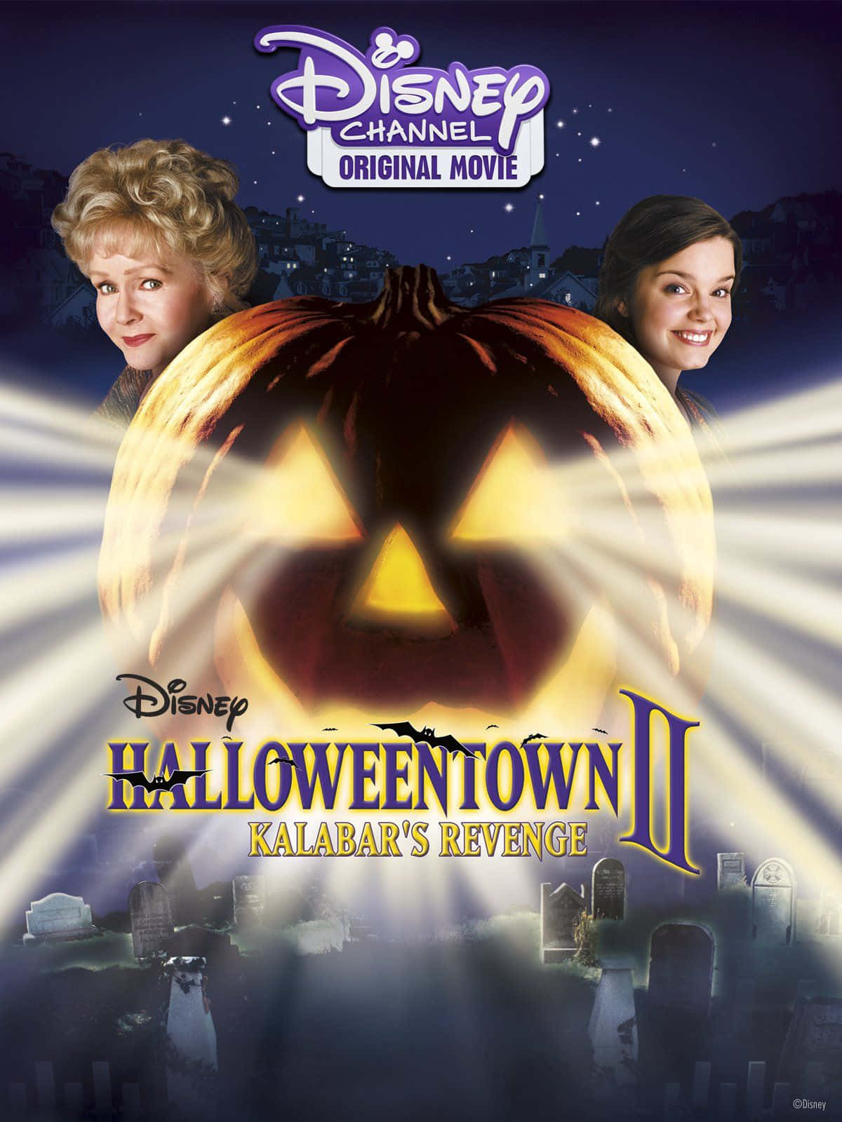 Halloweentown 桌布 壁紙 — 一個發光的南瓜燈在繁星點點的夜空下散發光芒，兩位微笑的女性在一個陰森的墓地上方分列兩側。