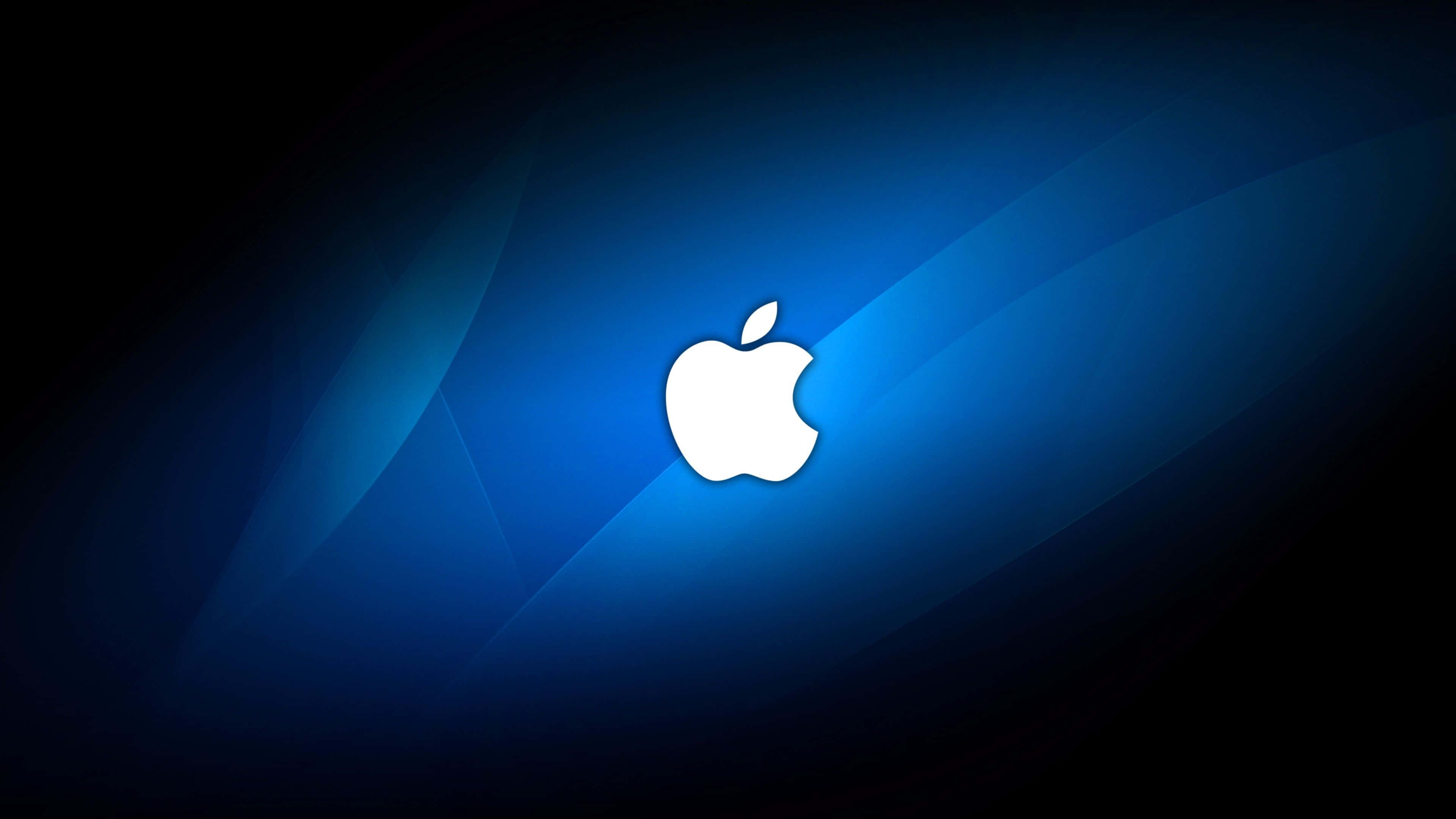 4K Apple 桌布 壁紙 — 一個發光的白色Apple標誌居中在帶有深色邊緣的漸變藍色背景上。