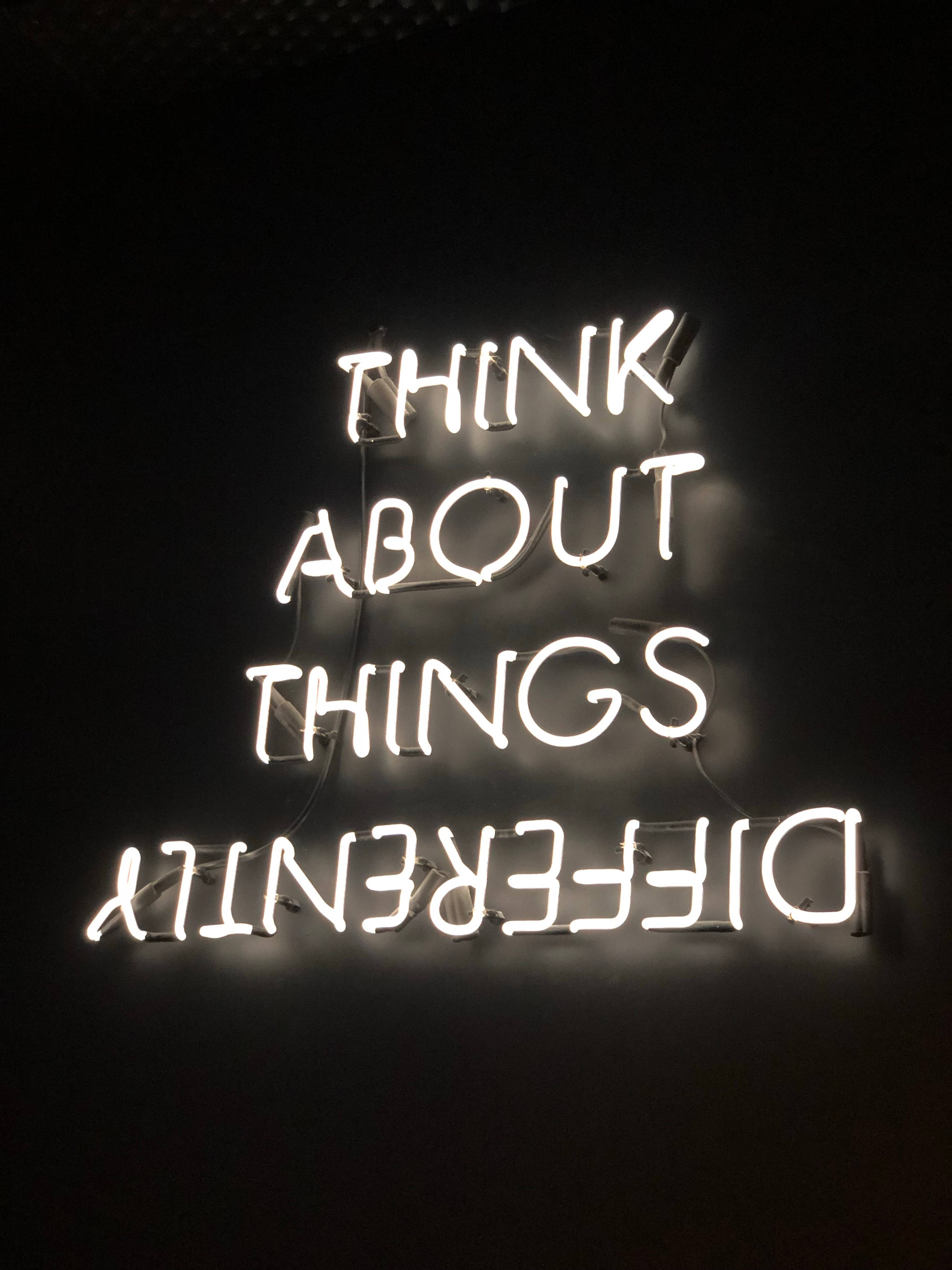 Positive Quotes 桌布 壁紙 — 一個發光的白色霓虹燈牌在暗牆上顯示「THINK ABOUT THINGS DIFFERENTLY」。