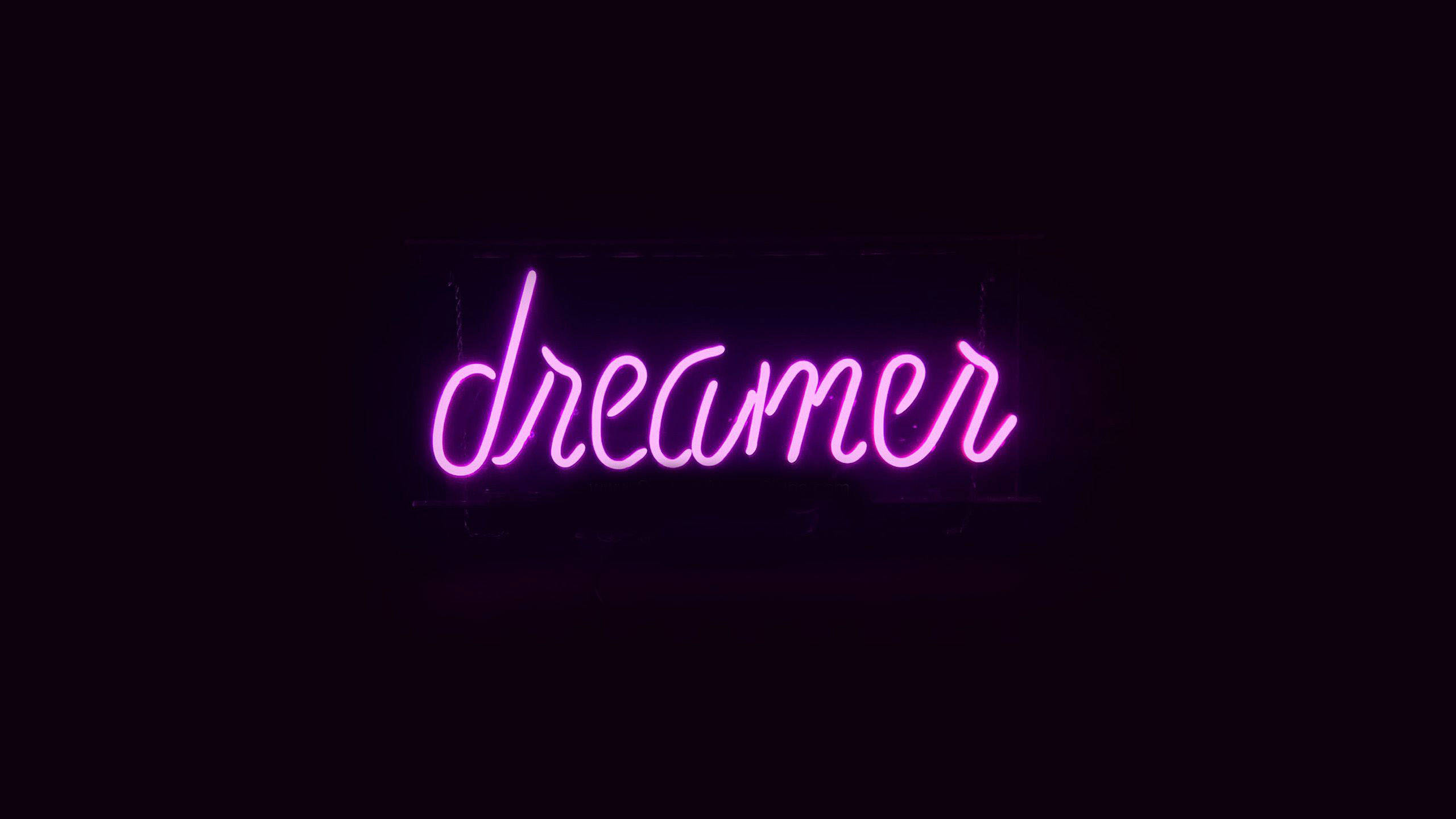 Neon Aesthetic 桌布 壁紙 — 一個發光的粉紅色霓虹燈牌，拼出dreamer，漂浮在漆黑的背景上。