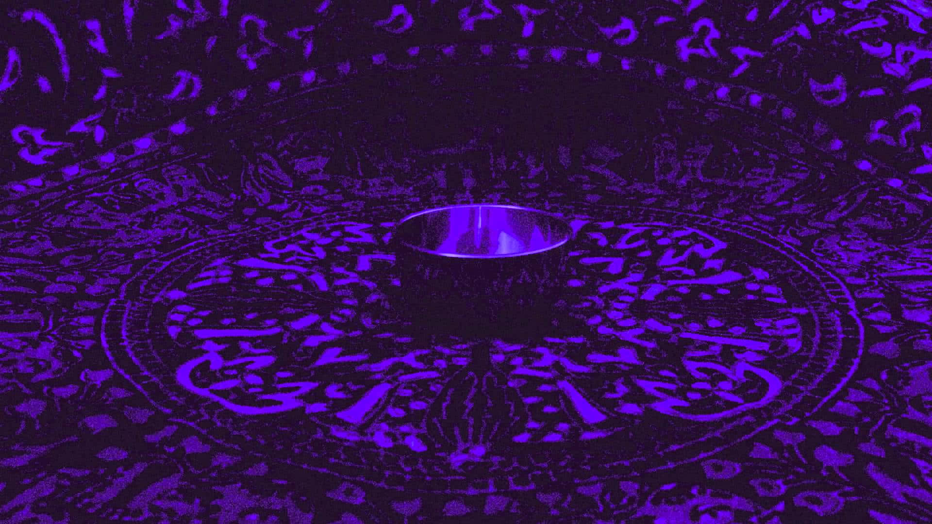 chakra 桌布 壁紙 — 一個發光的紫色杯子放置在裝飾性圓形圖案表面上，處於深紫色燈光下。