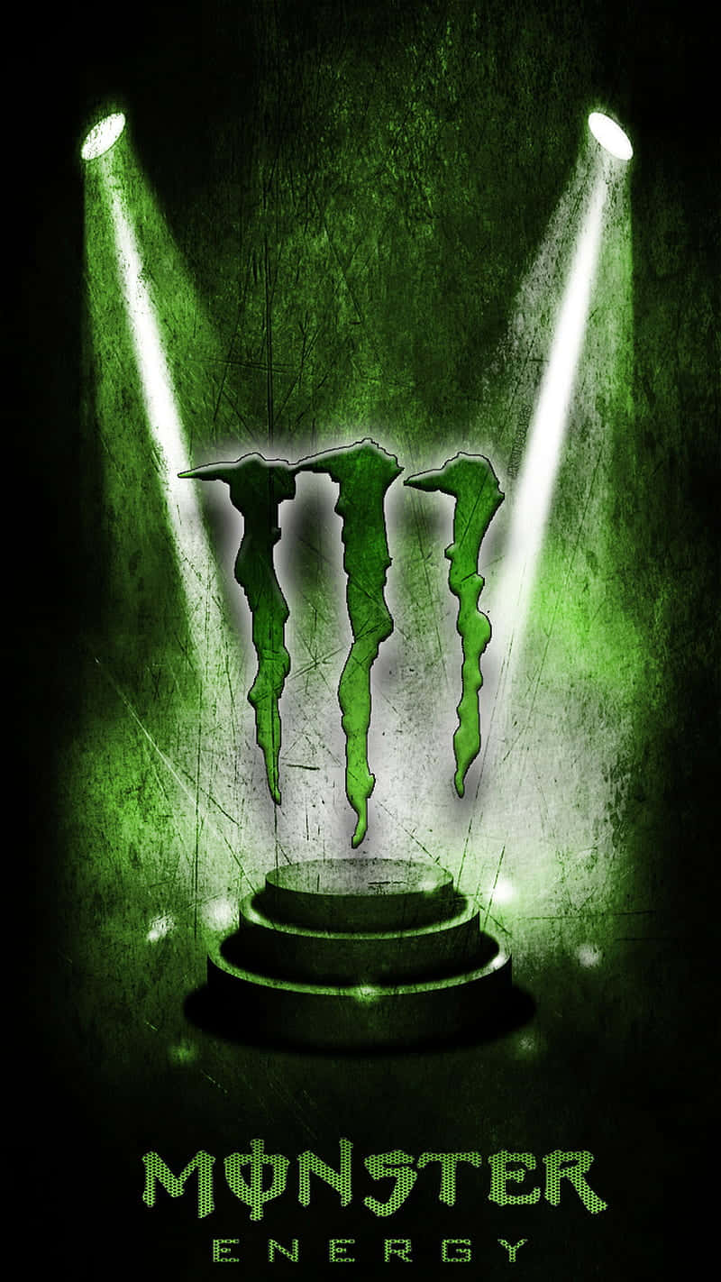 Monster Energy 桌布 壁紙 — 一個發光的綠色Monster Energy標誌，在粗糙的舞台上被兩個聚光燈照亮。