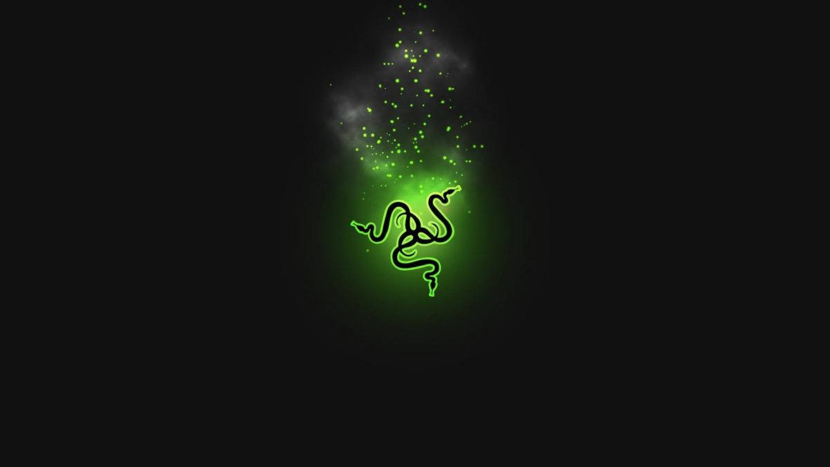 4K 桌布 壁紙 — 一個發光的綠色Razer標誌在黑暗背景上散發出閃爍的粒子。
