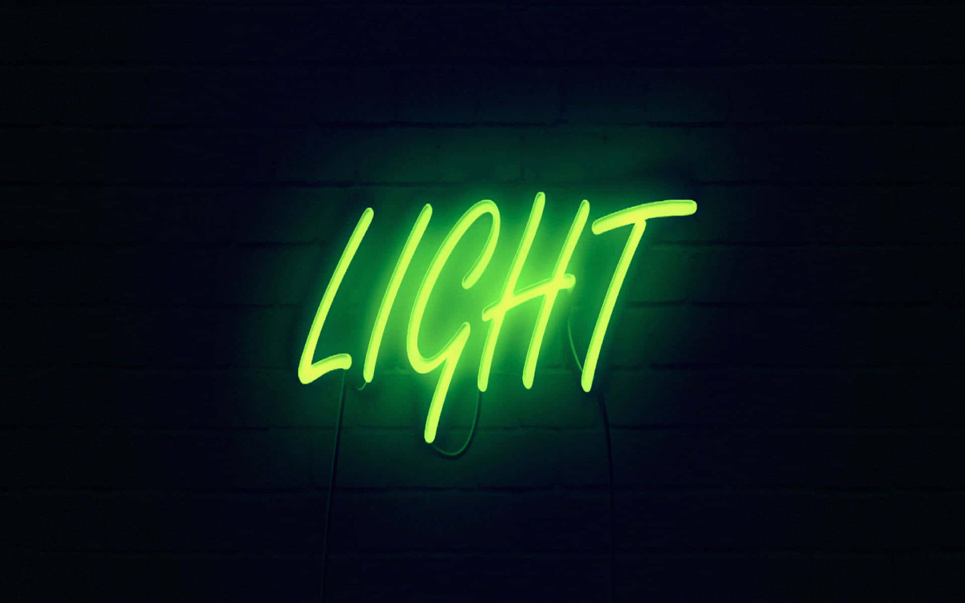 螢光綠美學 桌布 壁紙 — 一個發光的綠色霓虹燈牌，拼寫著「LIGHT」，在昏暗的環境中對著深色磚牆投射出鮮豔的光芒。