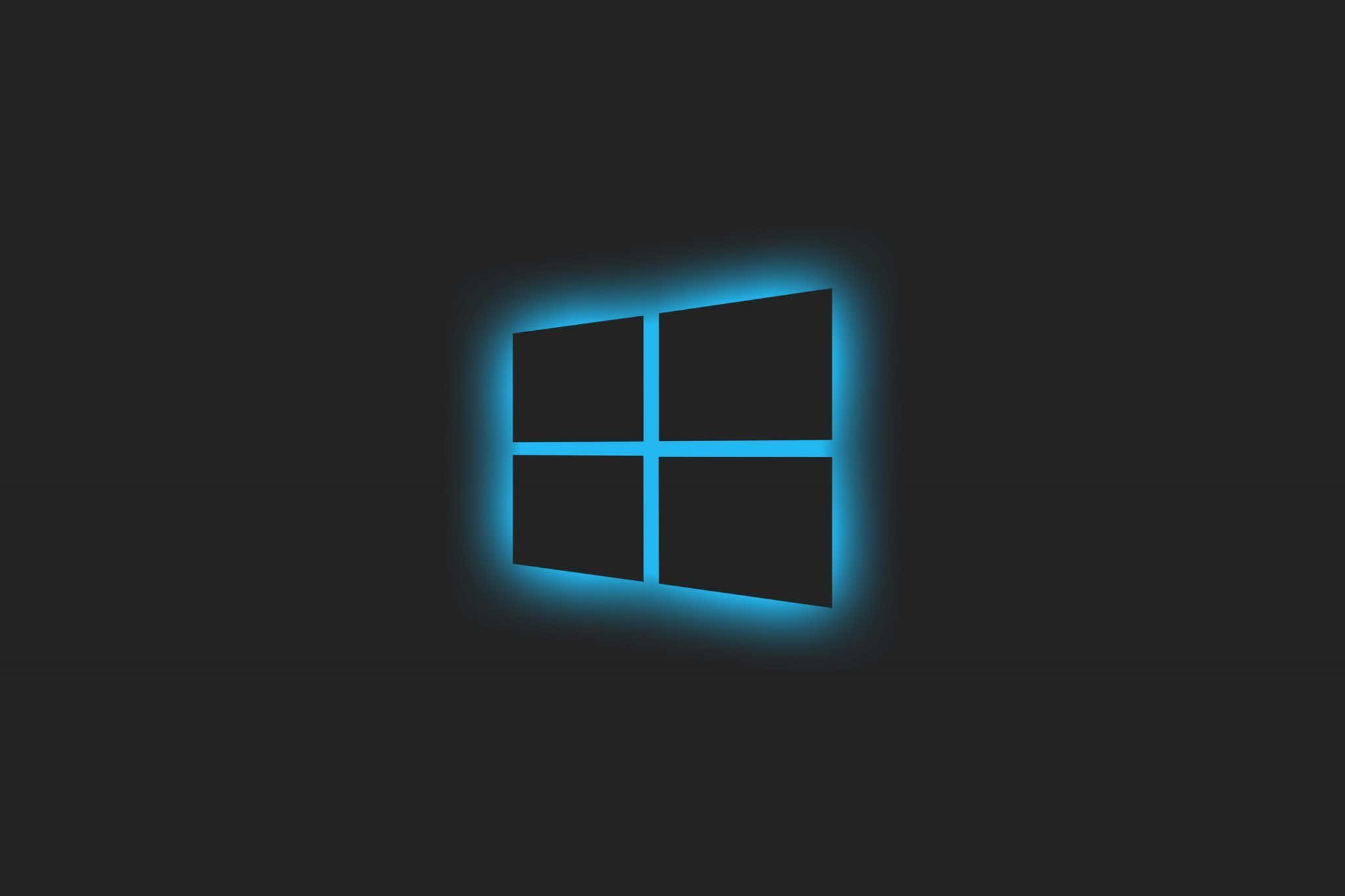 Theme 桌布 壁紙 — 一個發光的藍色Windows標誌，居中放置在深色背景上，邊緣散發出柔和的光芒。