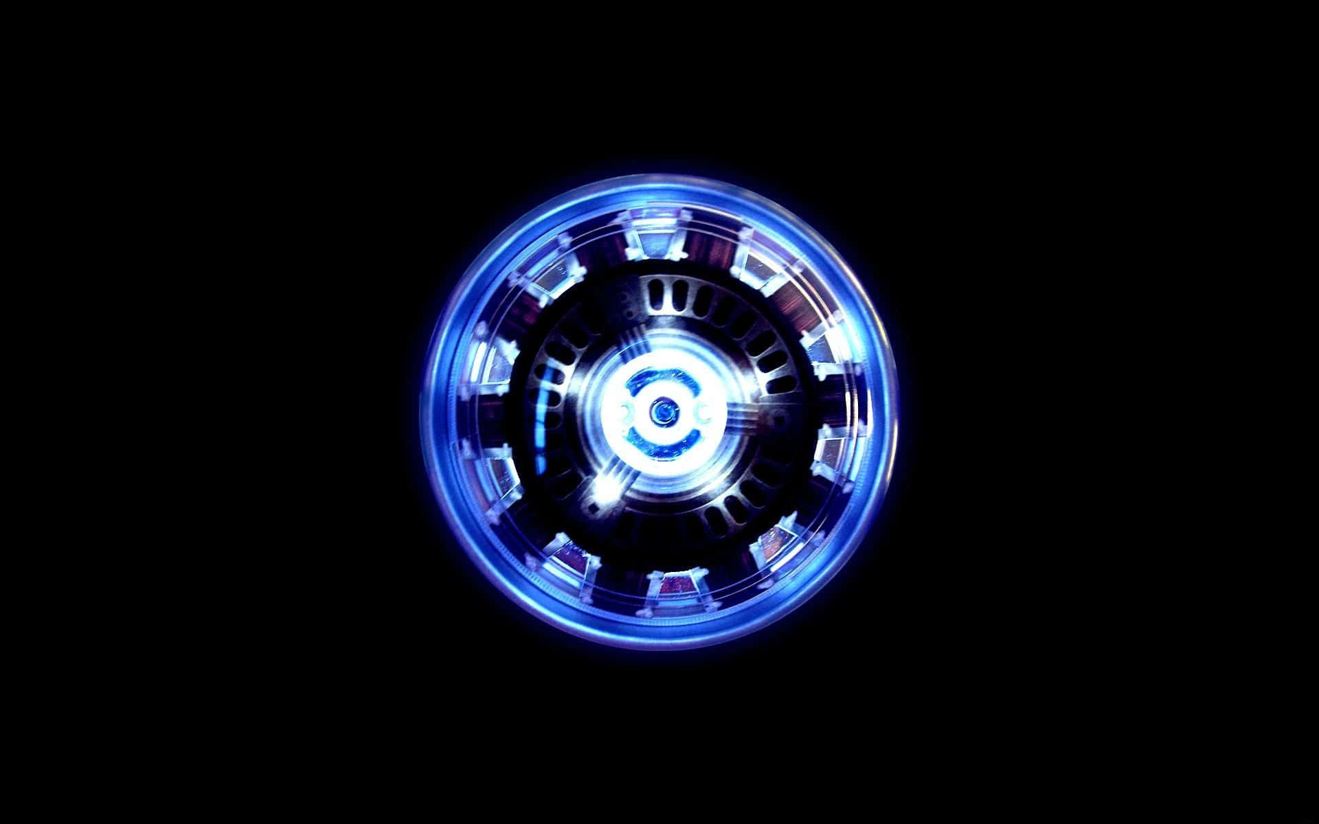 Iron Man Arc Reactor 桌布 壁紙 — 一個發光的藍色圓形弧形反應器在純黑色背景上脈動著能量。