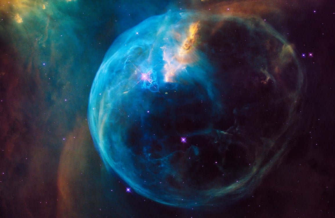 Interstellar Cloud 桌布 壁紙 — 一個發光的藍色泡泡星雲，帶有火熱的橙色觸鬚和閃爍的星星，背景是黑暗的宇宙。