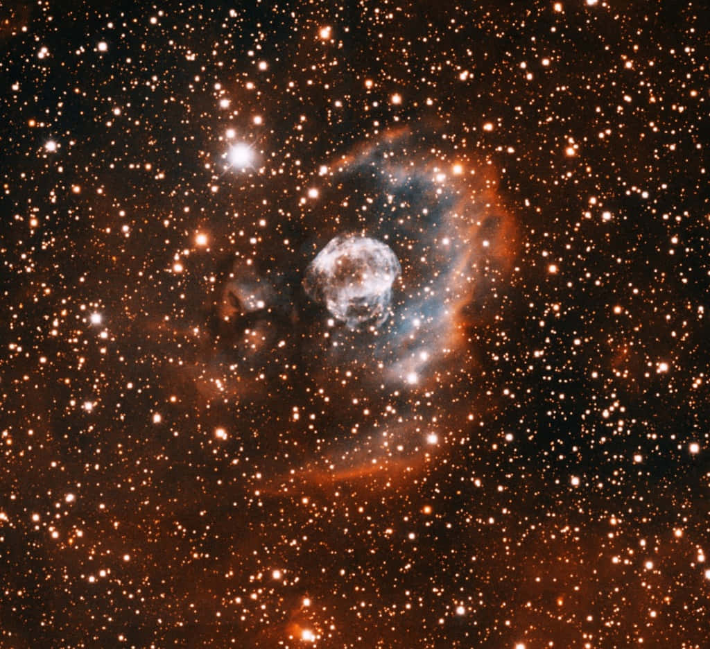 Planetary Nebula 桌布 壁紙 — 一個發光的行星狀星雲，帶有旋轉的藍色和橙色氣體，被深空中無數閃爍的星星包圍。
