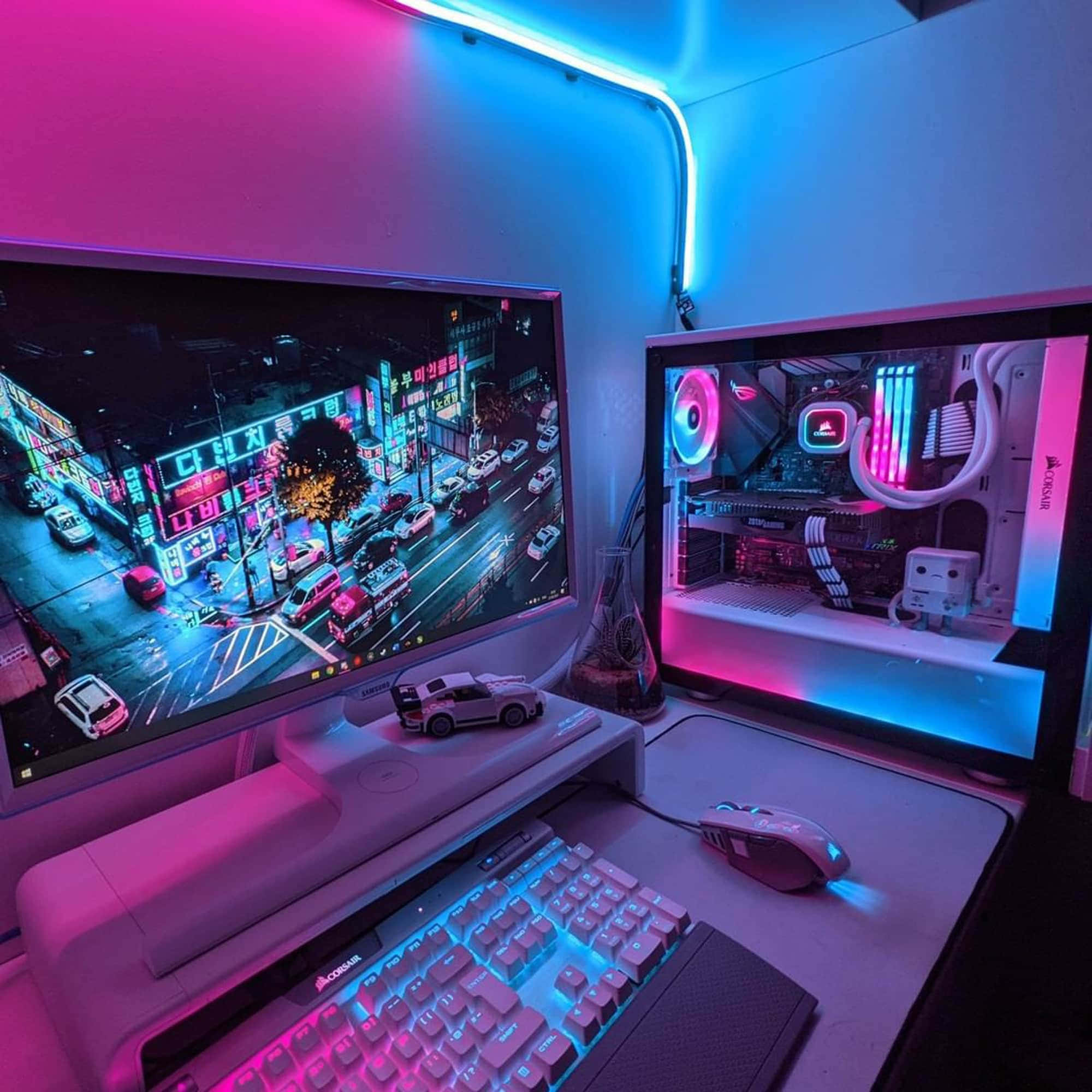 Gaming Pc Setup 桌布 壁紙 — 一個發光的遊戲設置，配備雙顯示器顯示霓虹城市景觀和RGB照明的PC組件，沐浴在粉紅色和藍色光中。