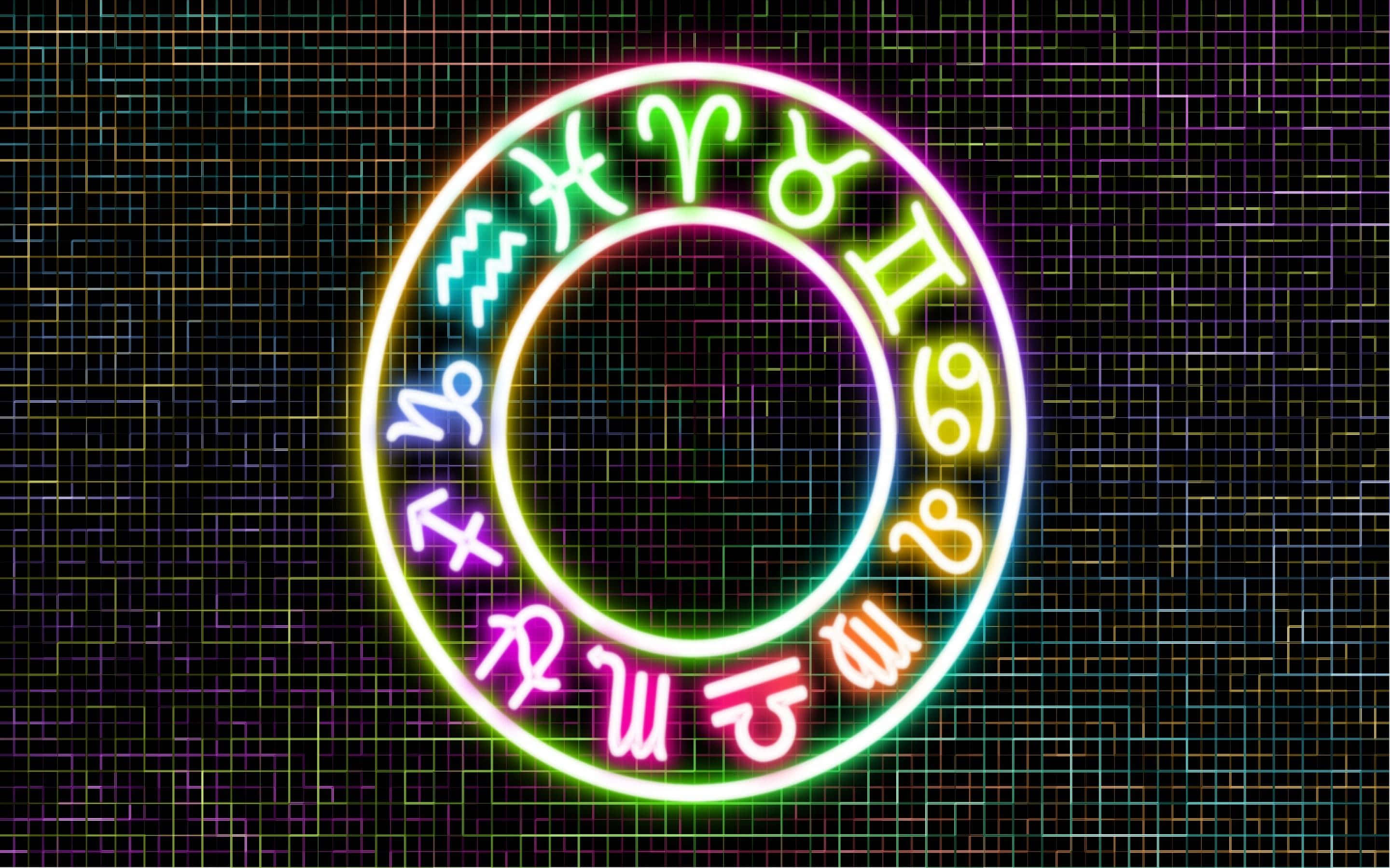 星座 桌布 壁紙 — 一個發光的霓虹星座輪，帶有鮮豔的彩虹符號，在黑暗的電路板背景下閃耀。