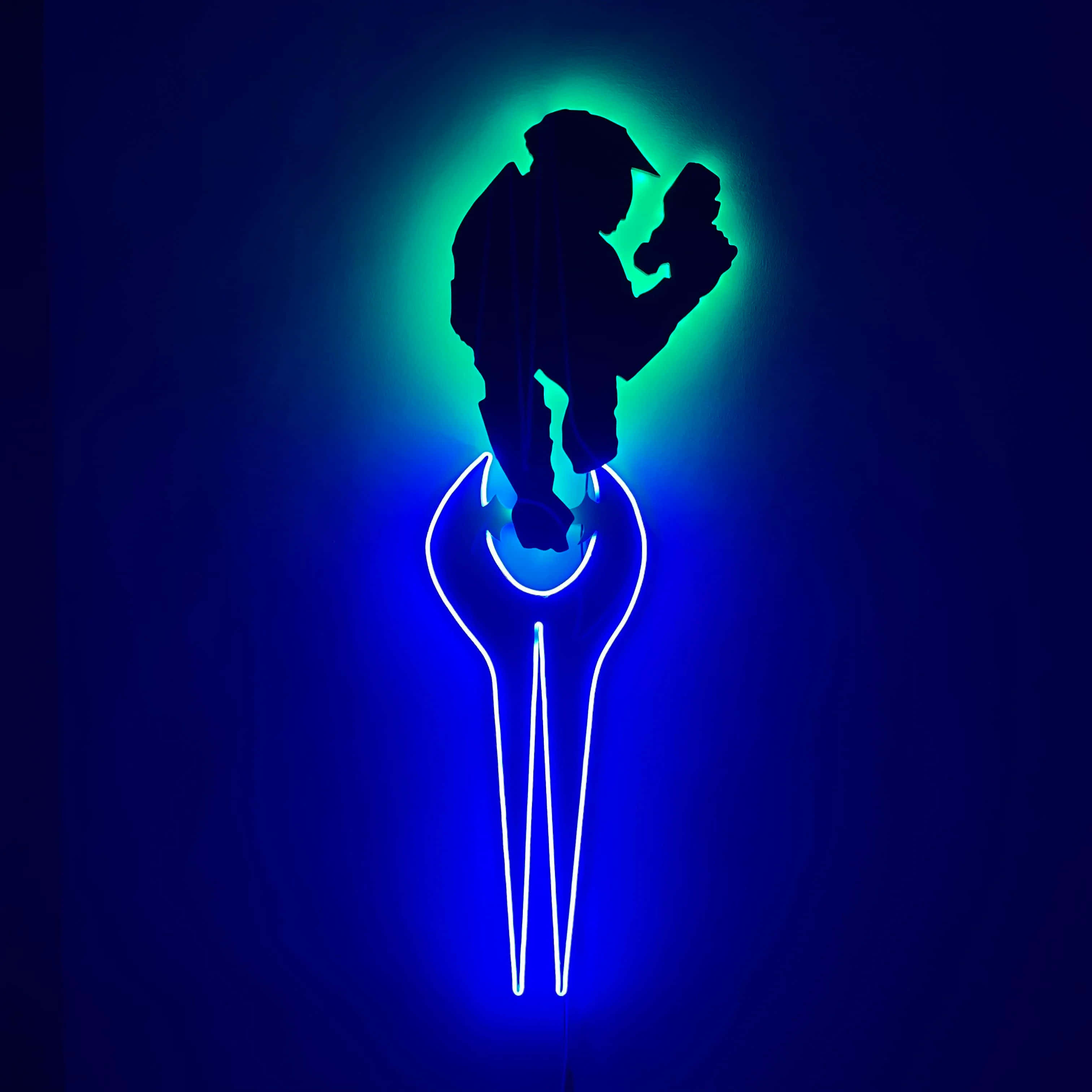 Halo Energy Sword 桌布 壁紙 — 一個發光的霓虹燈牌，在深藍色背景上顯示一個工人手持工具放在扳手形狀上方的剪影。