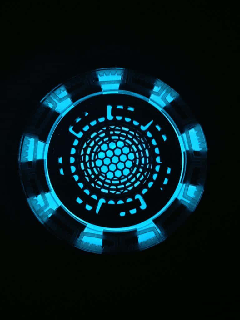 Iron Man Arc Reactor 桌布 壁紙 — 一個發光藍色圓形科幻裝置，帶有六邊形圖案和分段環，背景為黑色。