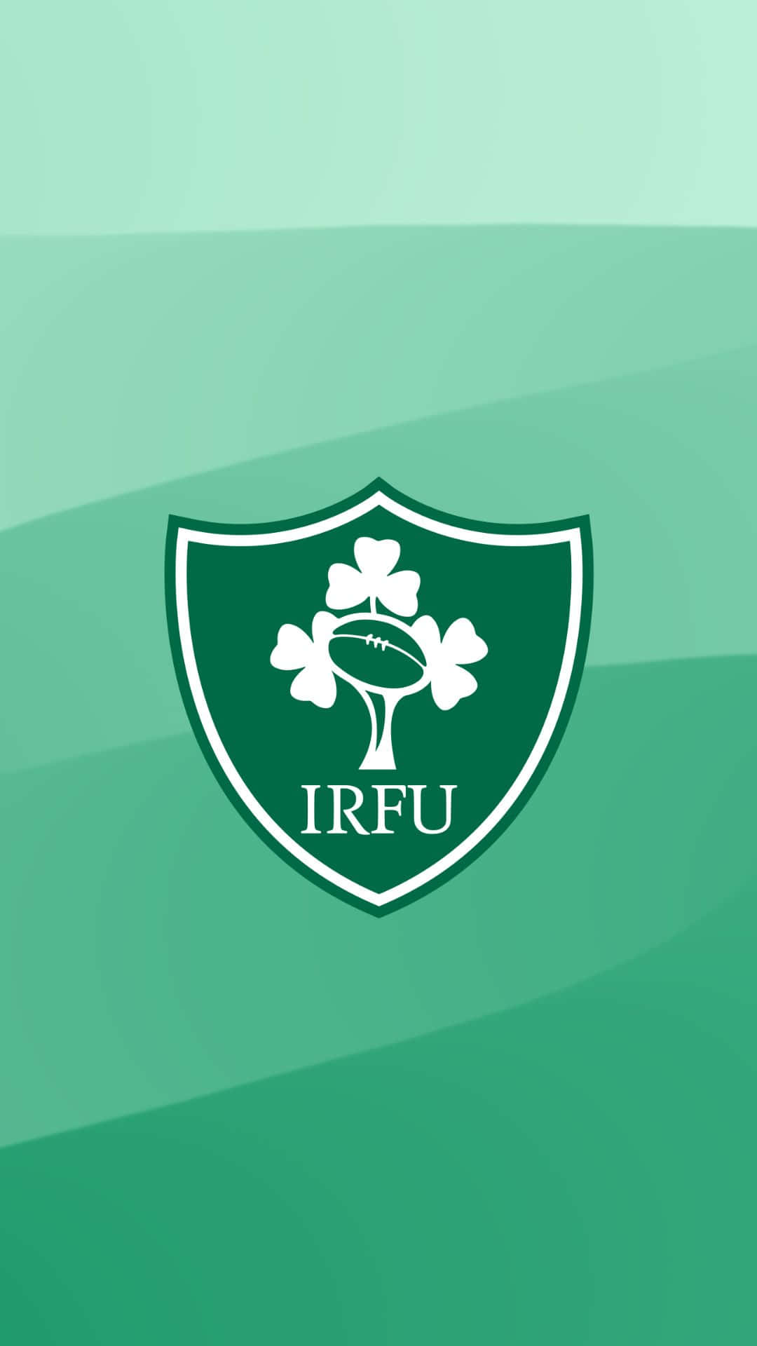 Ireland Rugby 桌布 壁紙 — 一個白色IRFU盾牌標誌，中央有一個三葉草和欖球，置於漸變綠色背景上。