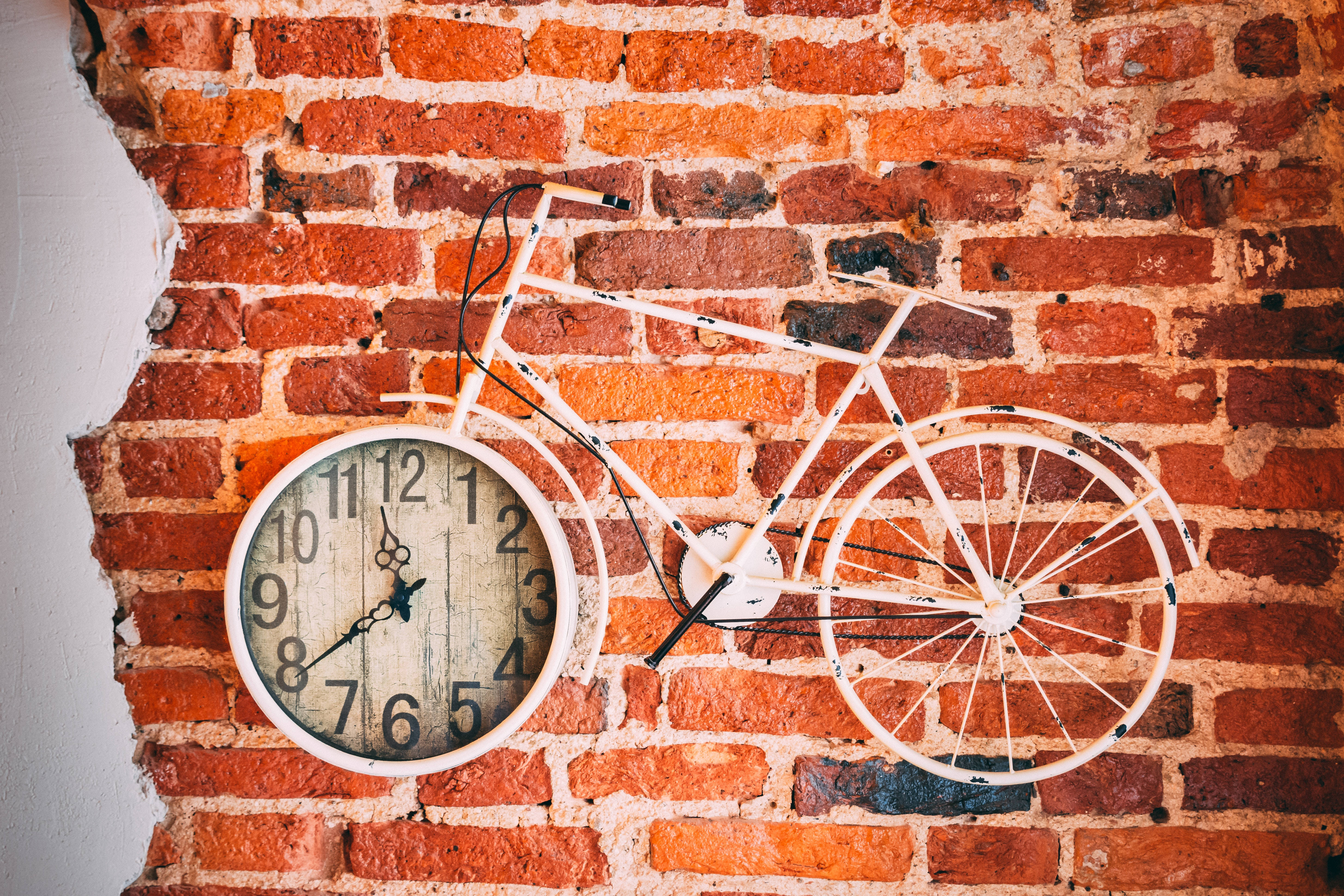 Clock 桌布 壁紙 — 一個白色單車時鐘安裝在帶有裸露砂漿的質樸紅磚牆上。