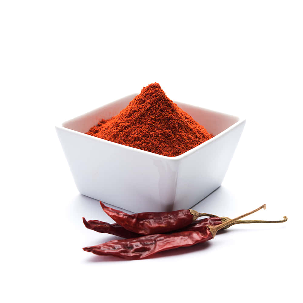 Red Chili Powder 桌布 壁紙 — 一個白色碗盛載著鮮紅色的辣椒粉，旁邊放有乾紅辣椒，置於潔白表面上。