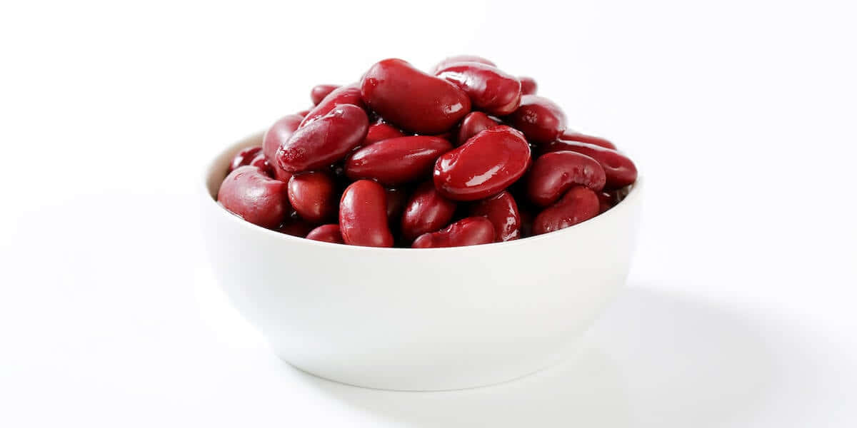 Red Beans 桌布 壁紙 — 一個白色碗裝滿了光澤的紅腰豆，背景是純白色。