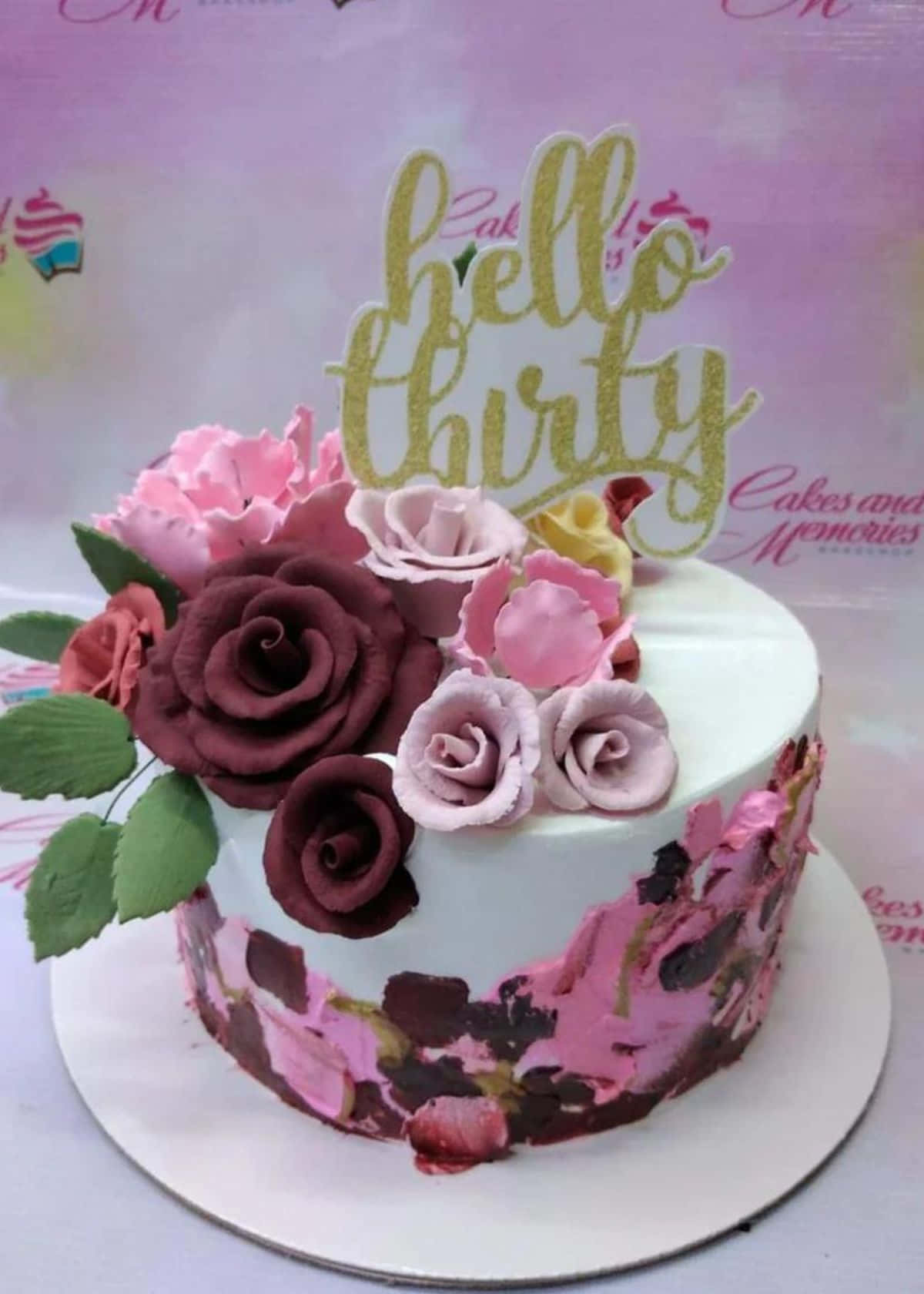 Floral Cake 桌布 壁紙 — 一個白色蛋糕，上面裝飾著粉紅色和酒紅色的翻糖玫瑰，以及一個閃亮的hello thirty蛋糕插牌。