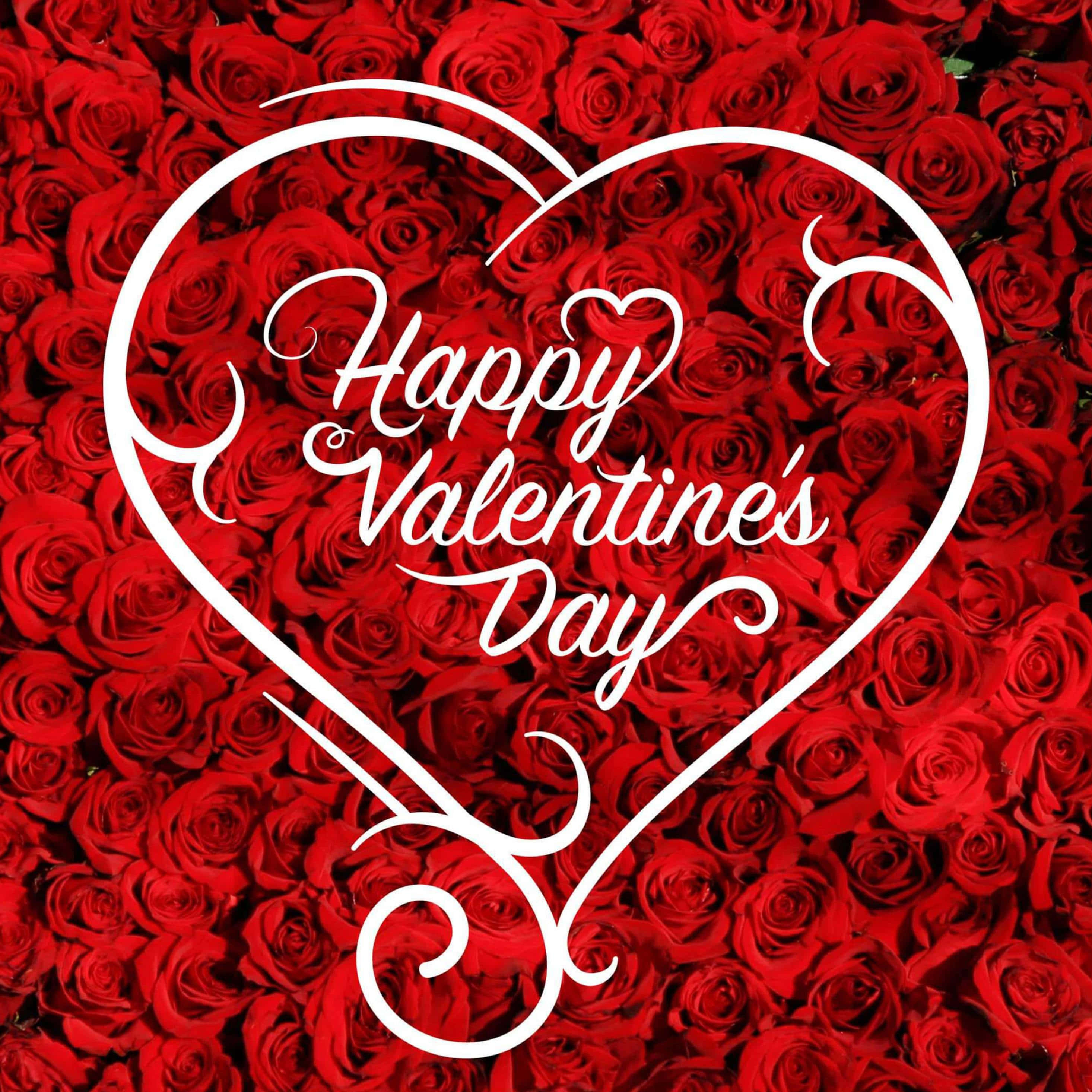 Happy Valentines Day 桌布 壁紙 — 一個白色裝飾心形，上面有「Happy Valentine's Day」字樣，覆蓋在密集的鮮紅玫瑰上。